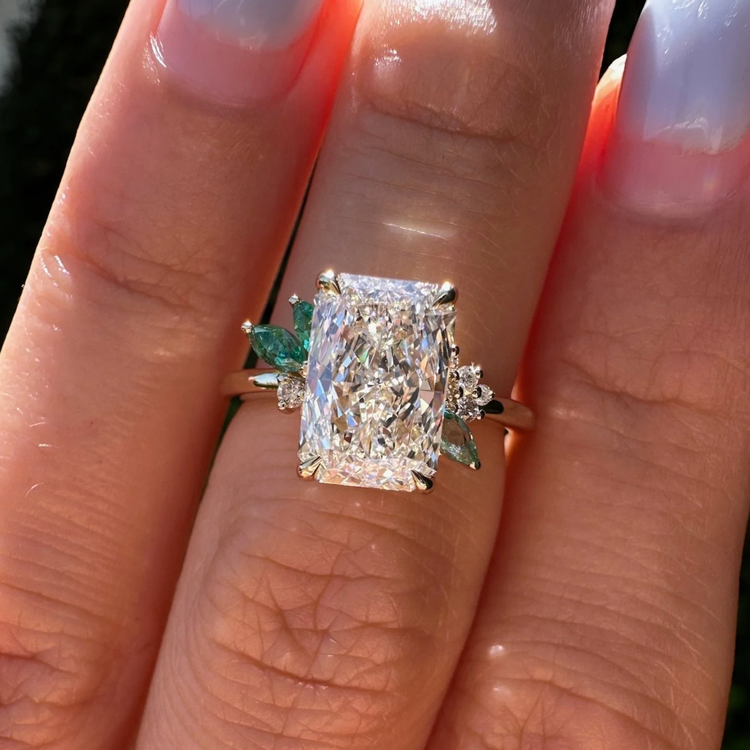 Custom-cut radiant diamond engagement ring with leaf-shaped green side stones