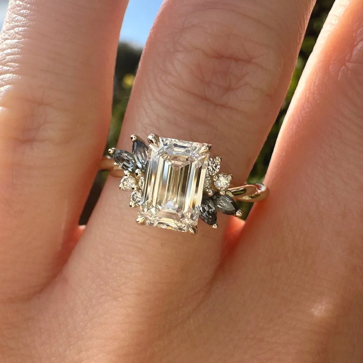 Emerald-cut diamond engagement ring with diamond and Madagascar sapphire side stones