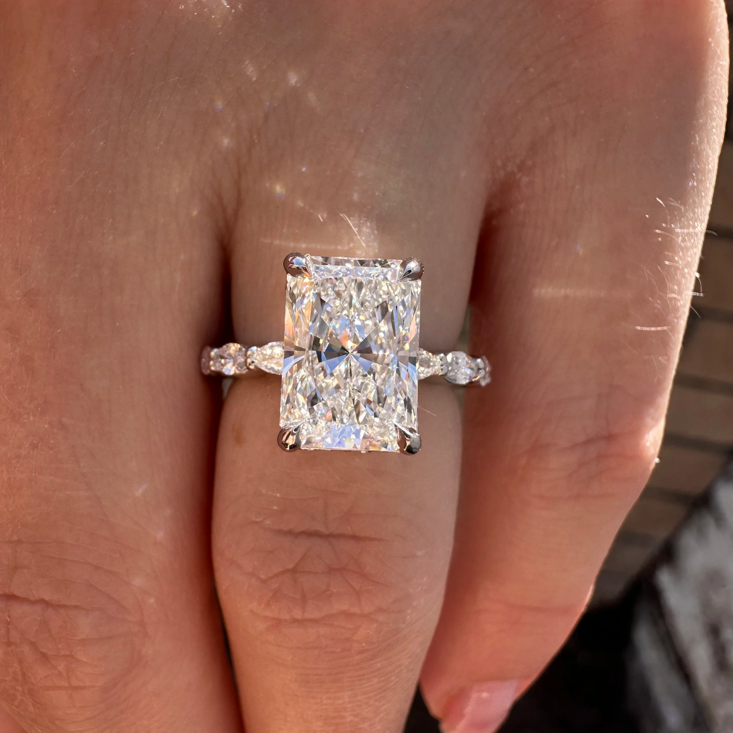 Radiant-cut diamond engagement ring with marquise diamonds on the band