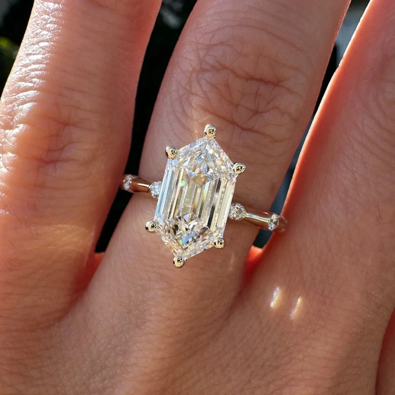 Elongated hexagon diamond engagement ring with side accents
