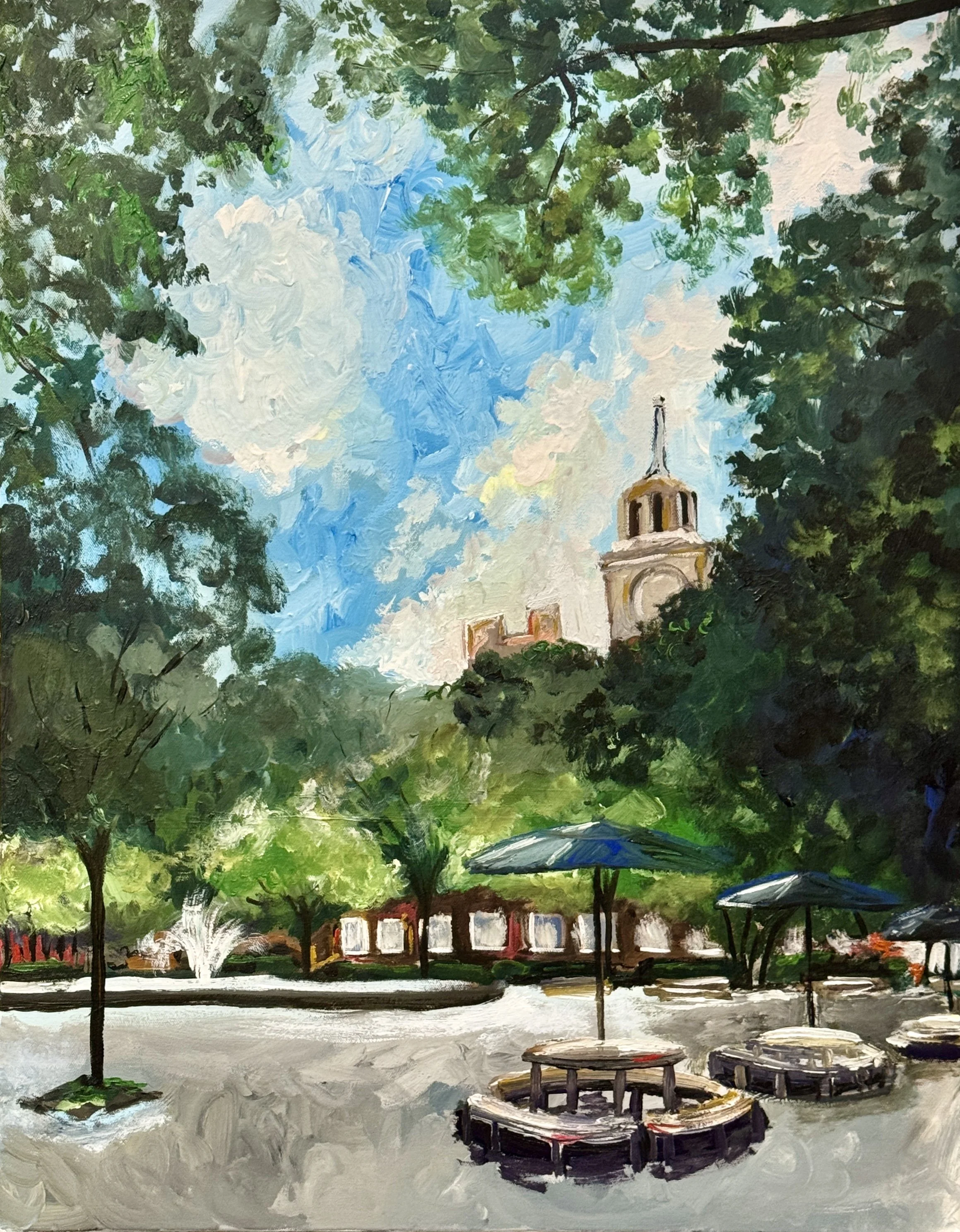 An impressionist style painting of a park scene with tall trees, a fountain with water spraying, white and red buildings in the background, and outdoor tables with umbrellas.