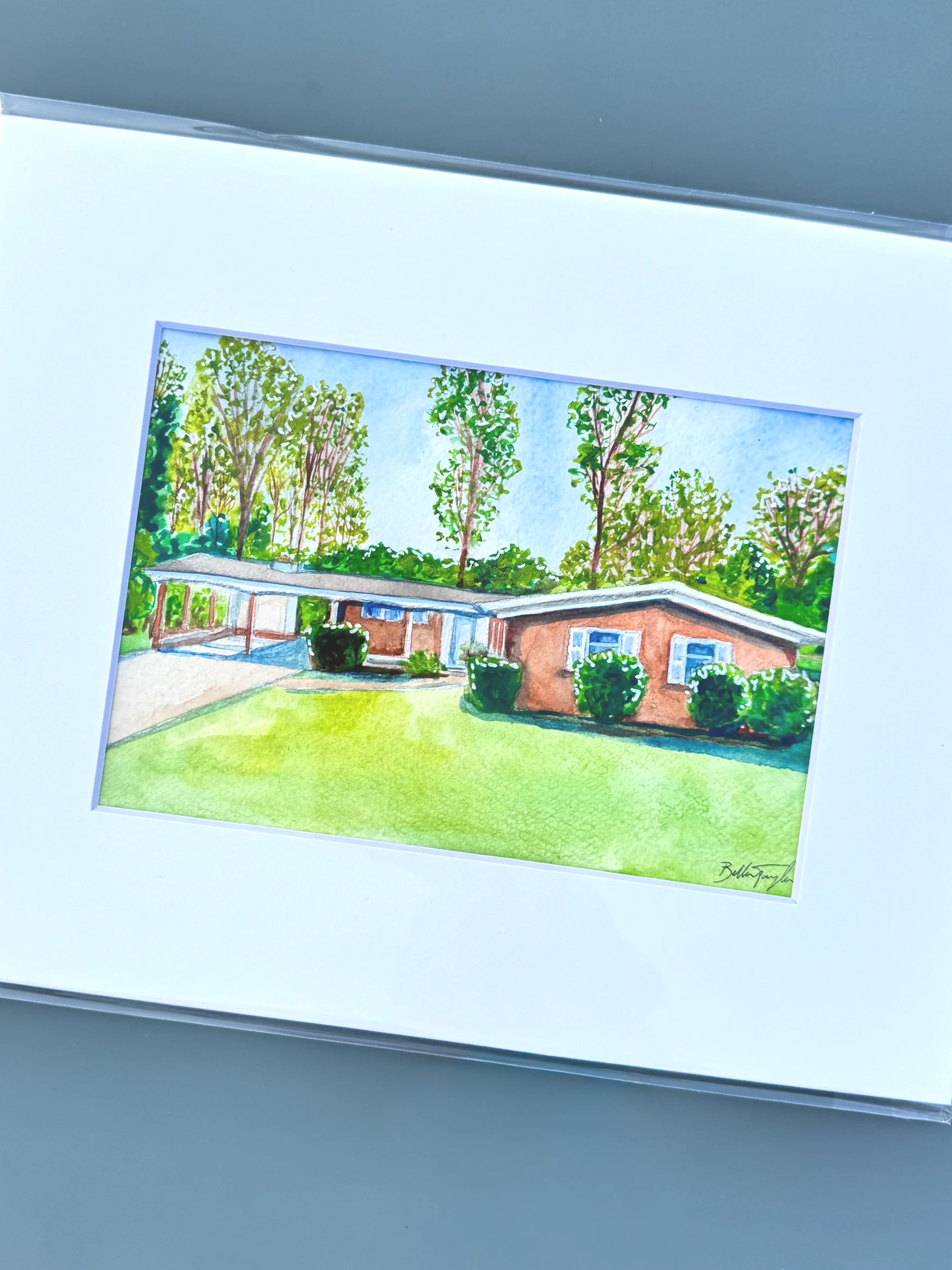 Colorful watercolor painting of a house with a red brick exterior and a flat roof, surrounded by green shrubs and tall trees, under a blue sky.