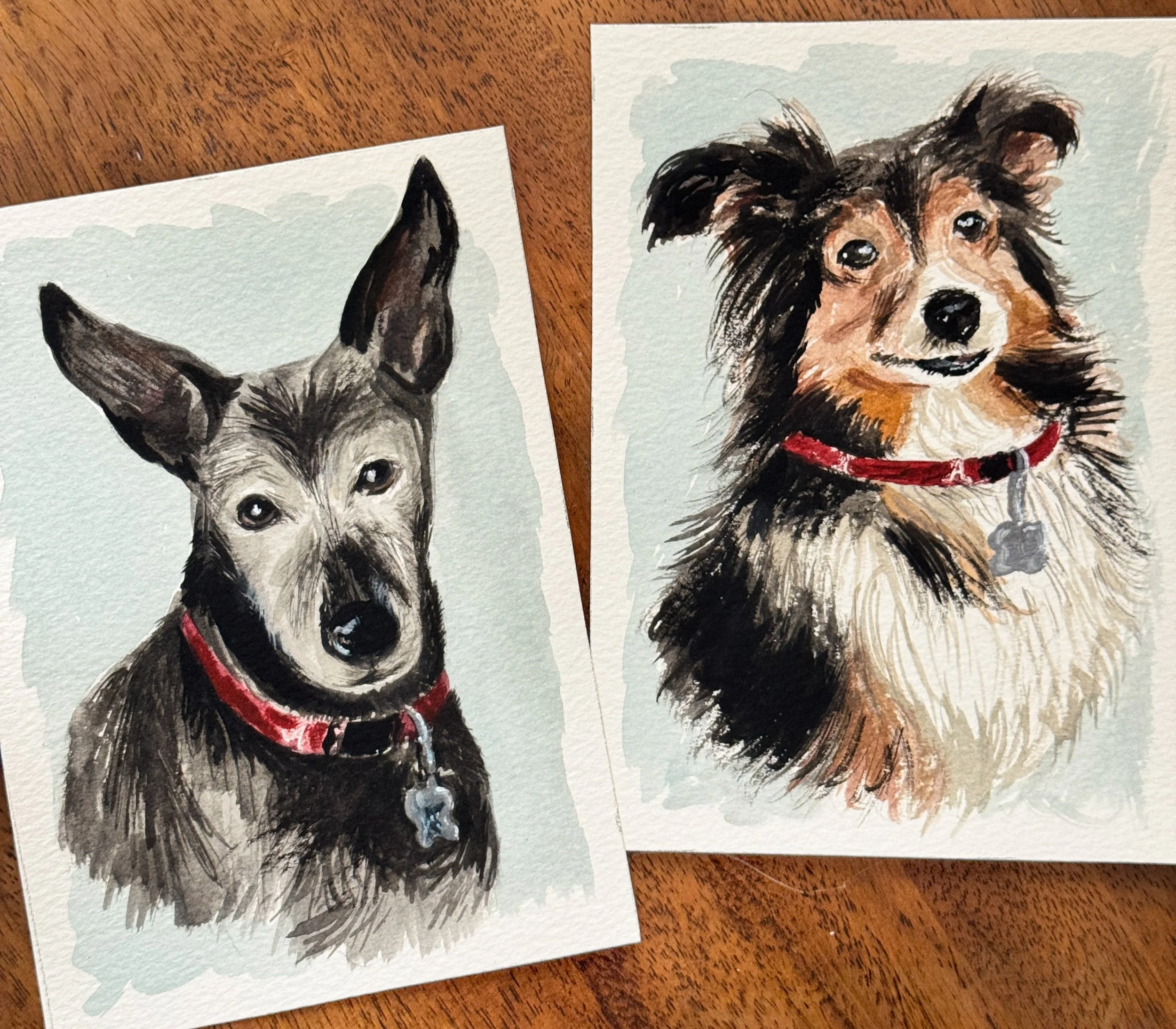 Watercolor paintings of a Siberian Husky and a Border Collie dogs placed on a wooden surface.