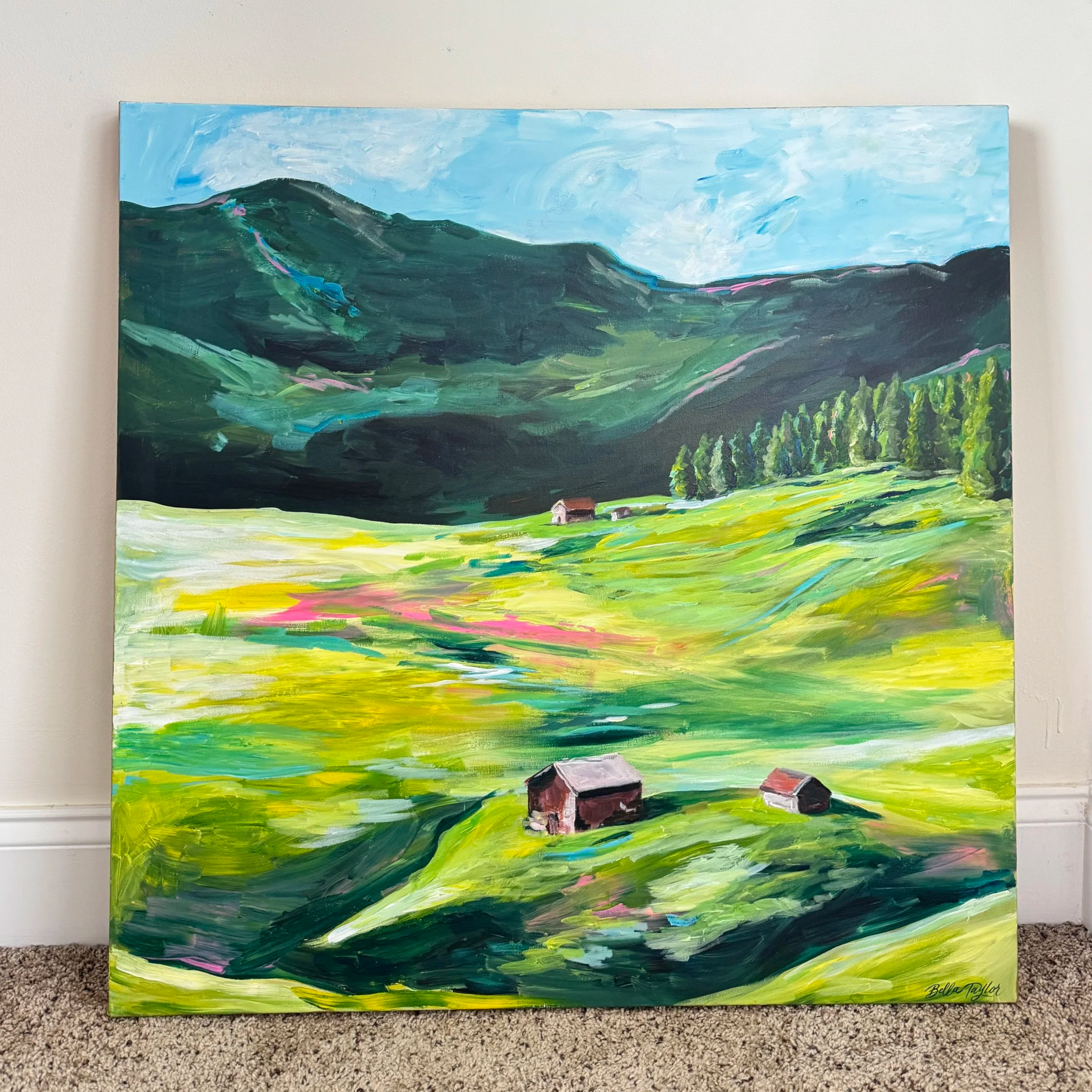 A colorful landscape painting depicting green rolling hills, a small house in the foreground, and a sky with clouds. The painting features vivid brushstrokes and is signed in the bottom right corner by Bella Taylor.