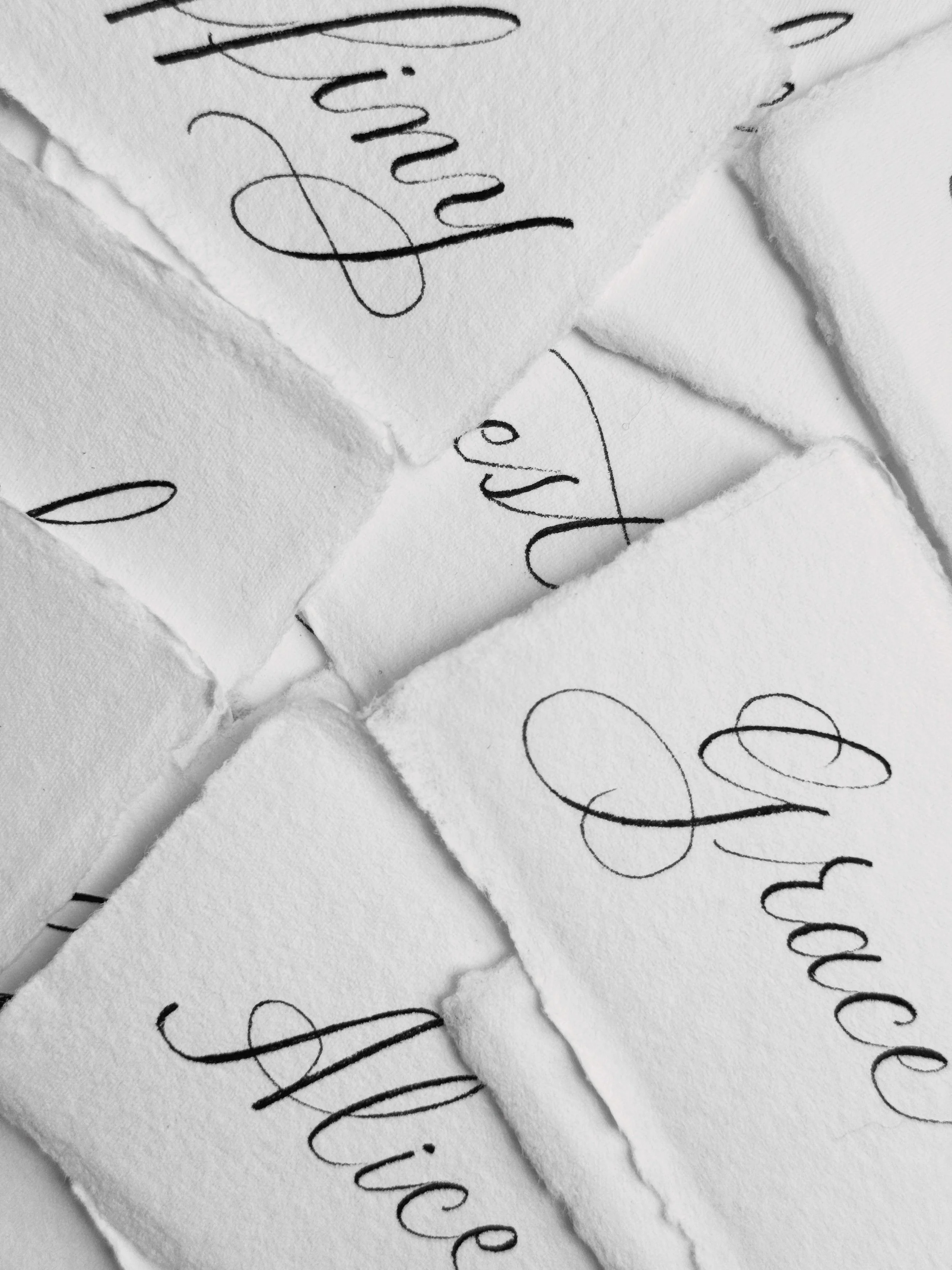 White place cards of names written in calligraphy. 