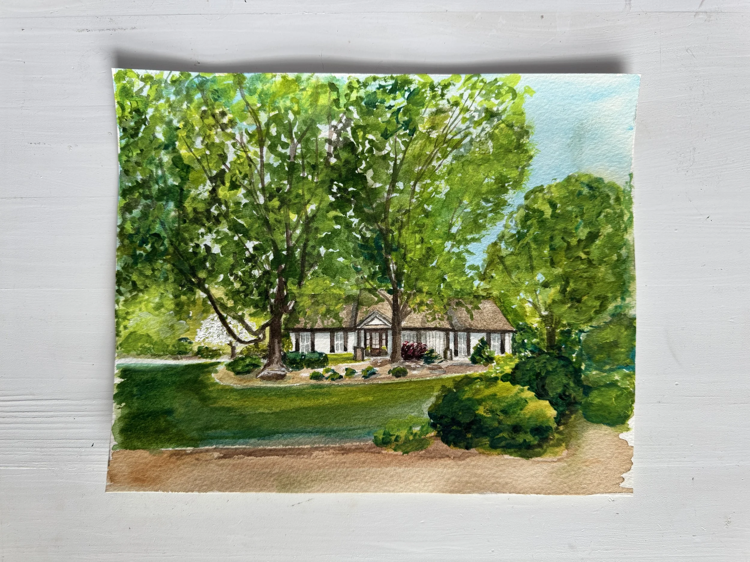 Watercolor painting of a house surrounded by trees and greenery, with a bright sky background.