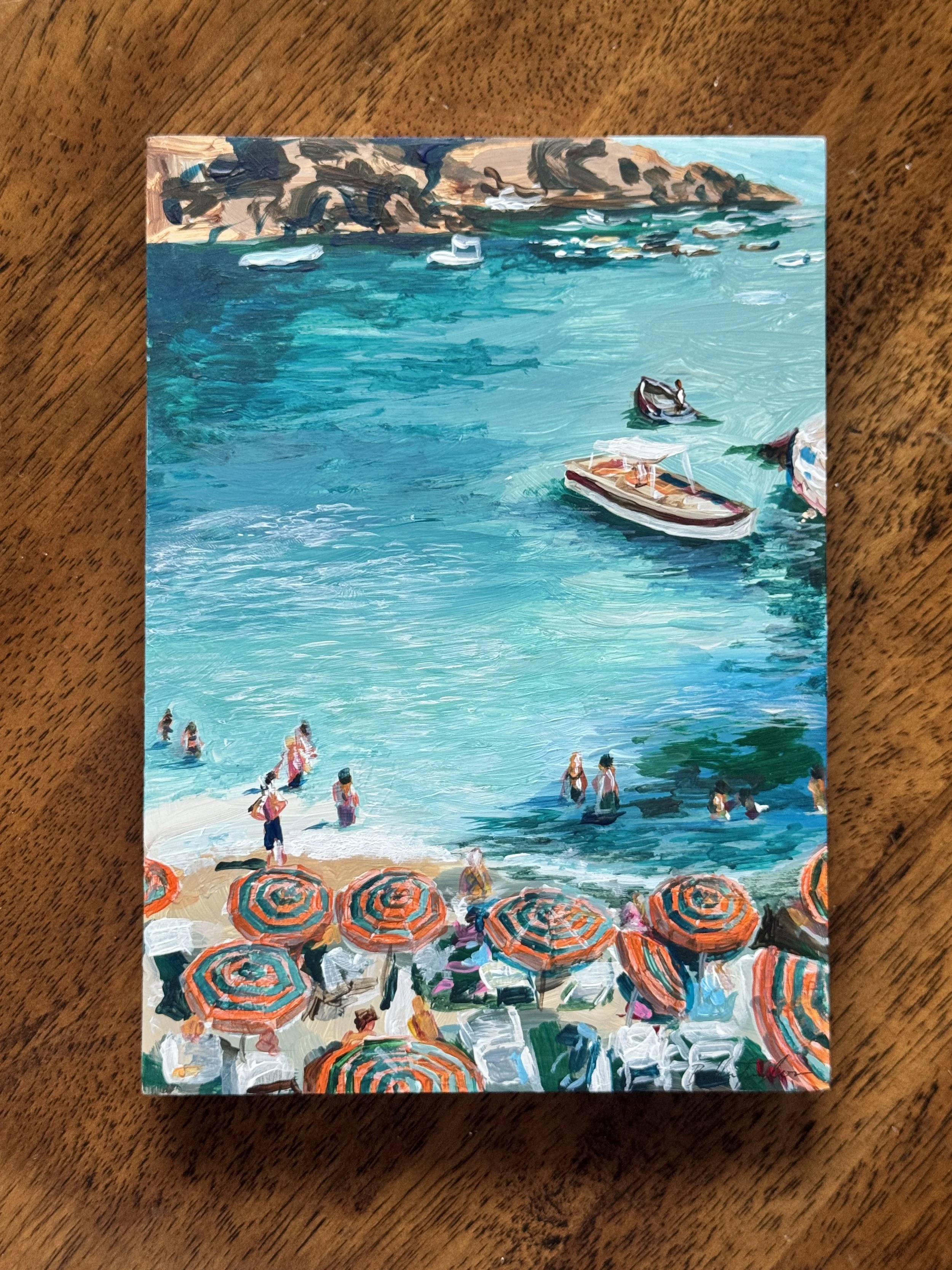 An impressionistic painting of a beach scene with turquoise water, boats, rocky cliffs in the background, and beach umbrellas in the foreground.