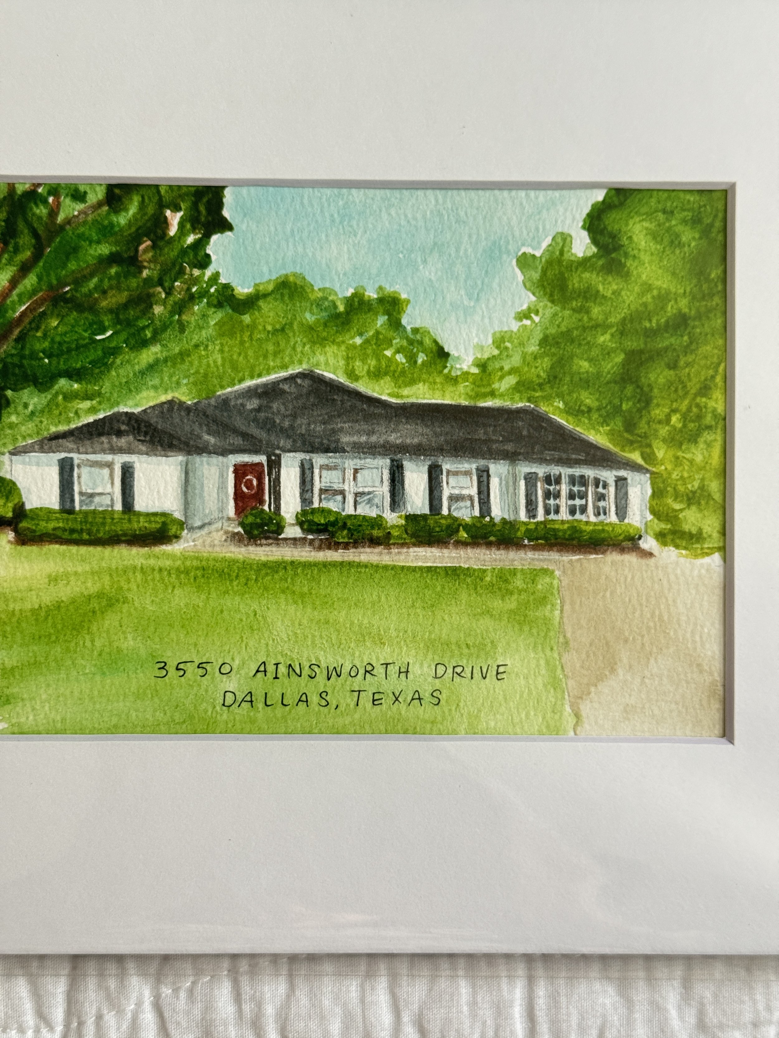 A watercolor painting of a house surrounded by trees and bushes.