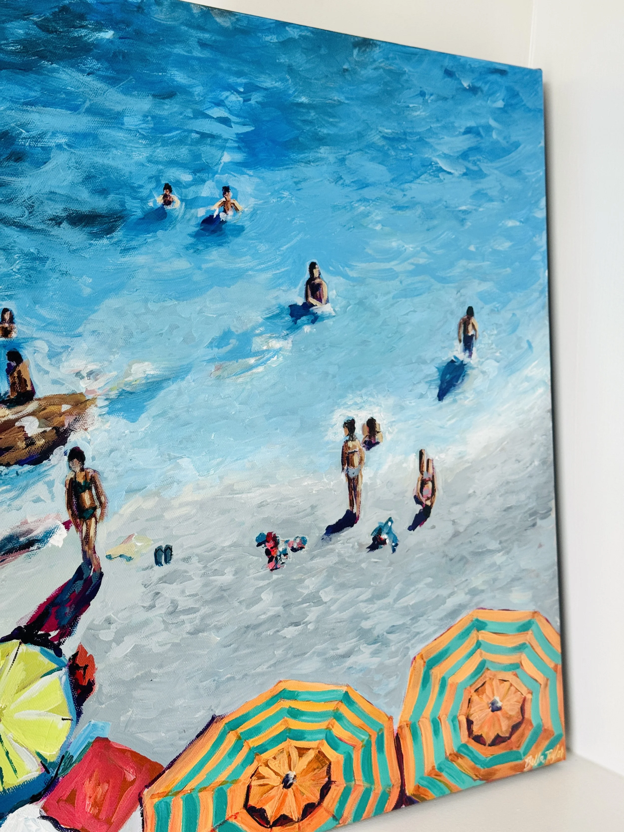 Painting of people swimming at the beach with colorful umbrellas on the sandy shore.