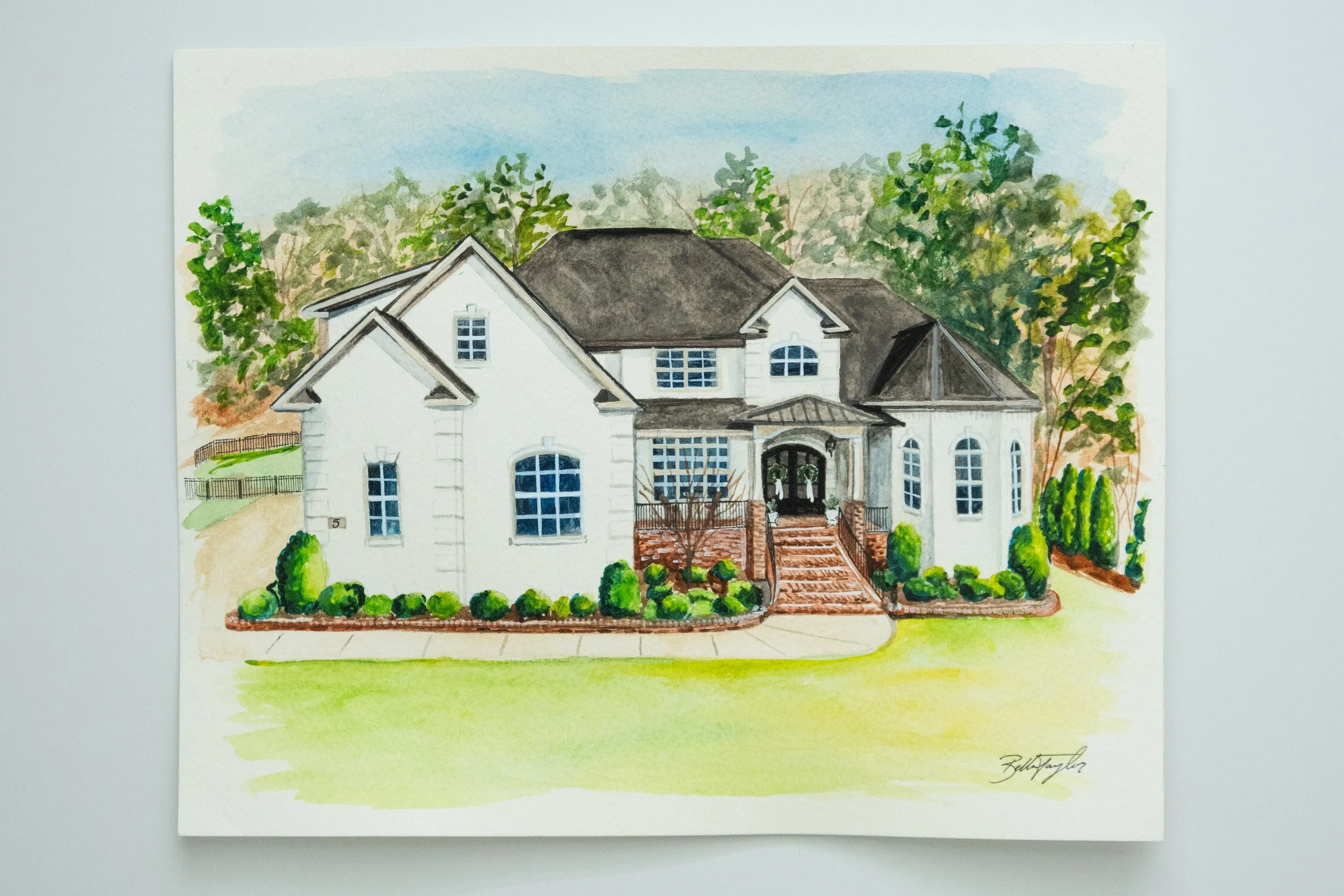 Watercolor painting of a two-story white house with a dark roof, front porch, surrounded by trees and landscaping.
