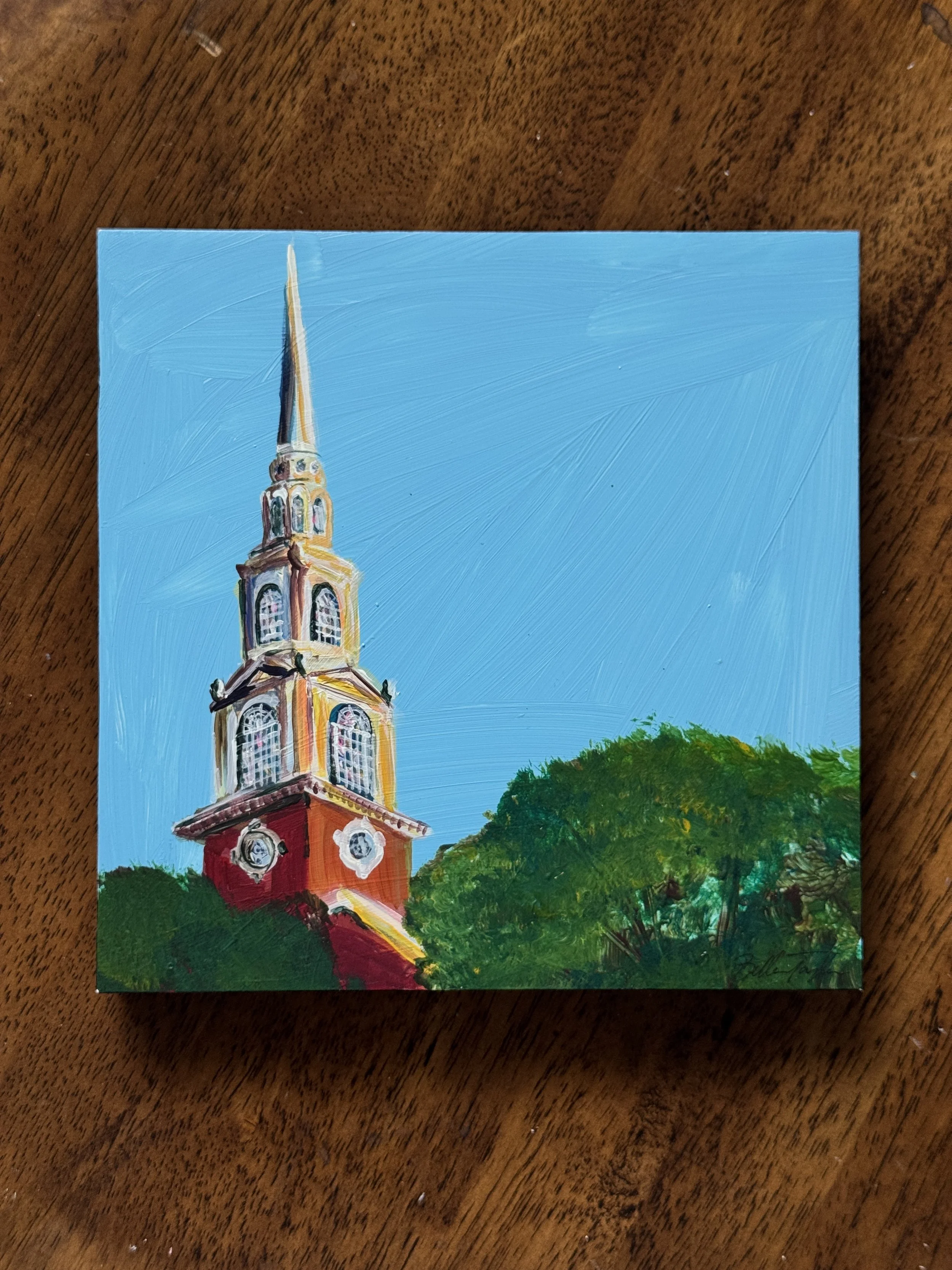 A colorful painting of a church with a tall, pointed steeple, set against a bright blue sky and surrounded by green trees.