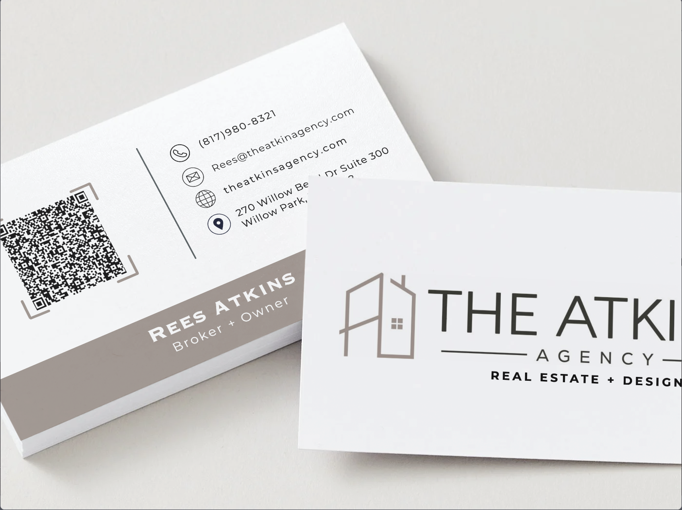 Business cards for the Atkins Agency, a real estate and design firm, featuring the company logo, contact information, and a QR code.