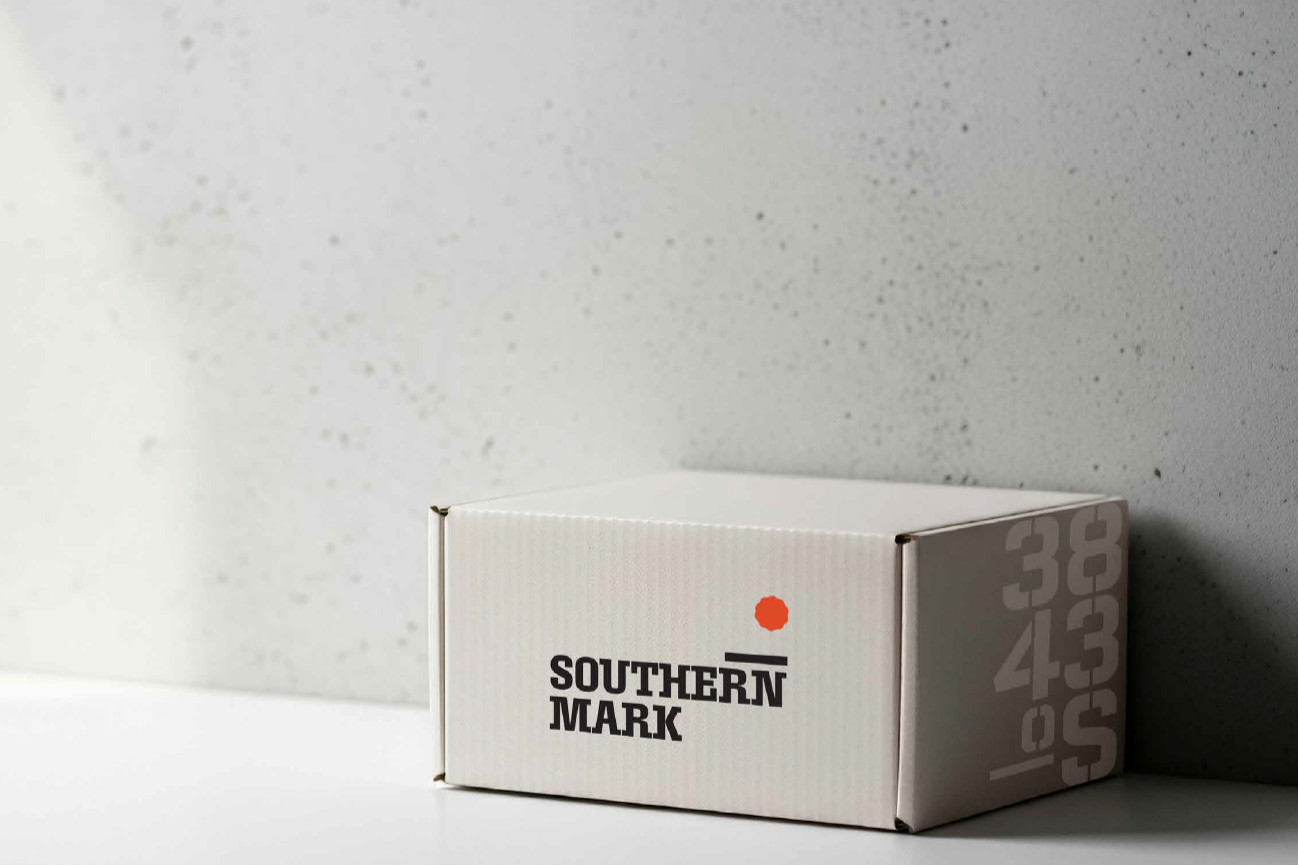 A white box with the text 'Southern Mark' and an orange dot on it, placed against a speckled gray wall background.