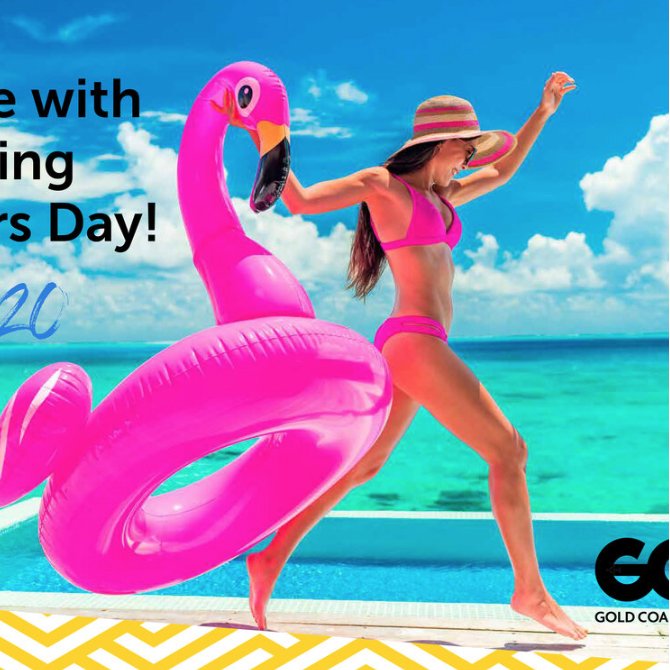 A woman in a pink bikini and a sunhat, holding a large pink inflatable flamingo, standing by a pool with a beach and ocean in the background, celebrating Mother's Day.