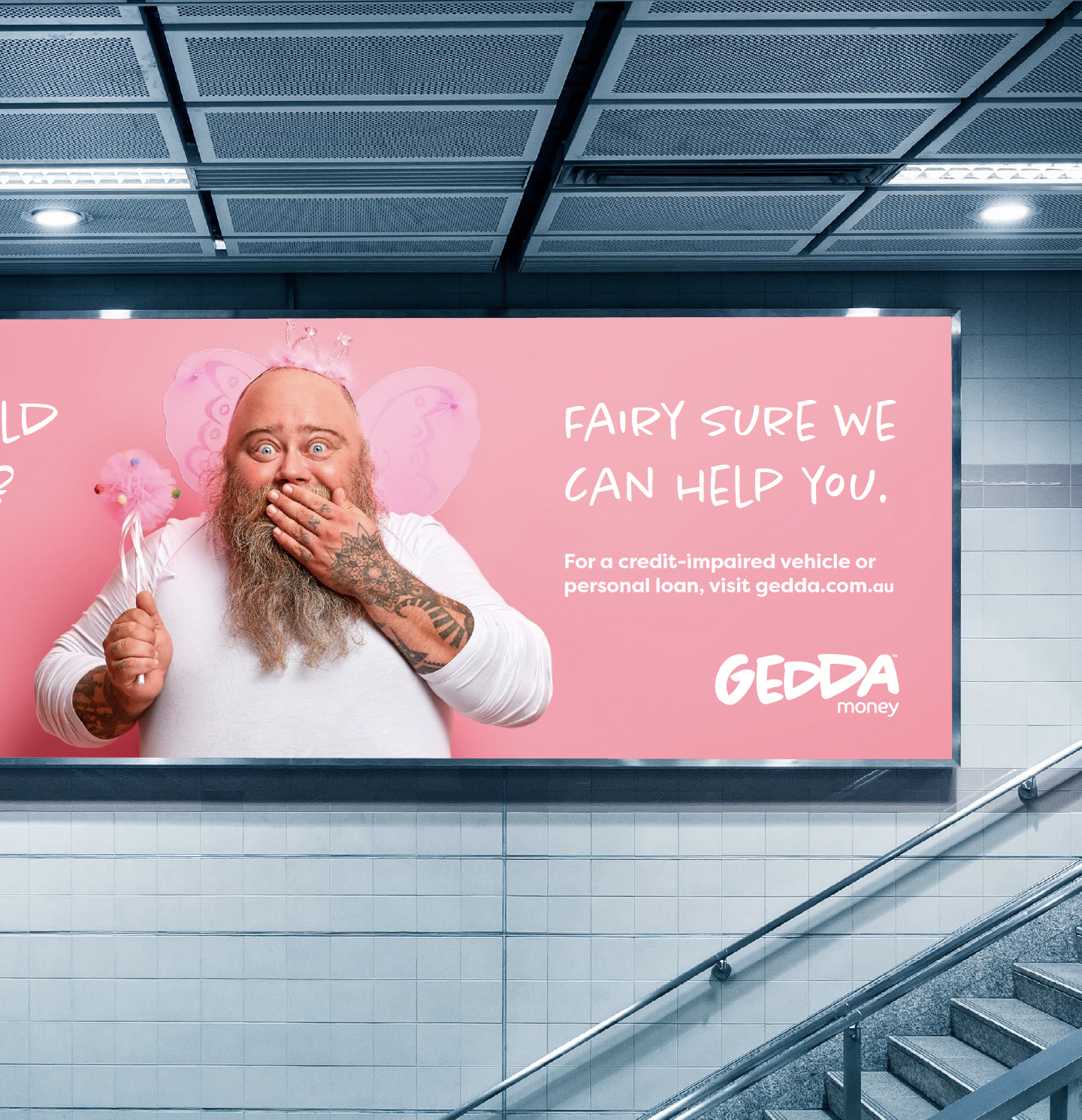 A man with a beard, tattoos, and fairy wings holding a pink cotton candy and covering his mouth in surprise, standing in front of a pink advertisement poster for Gedda Money.
