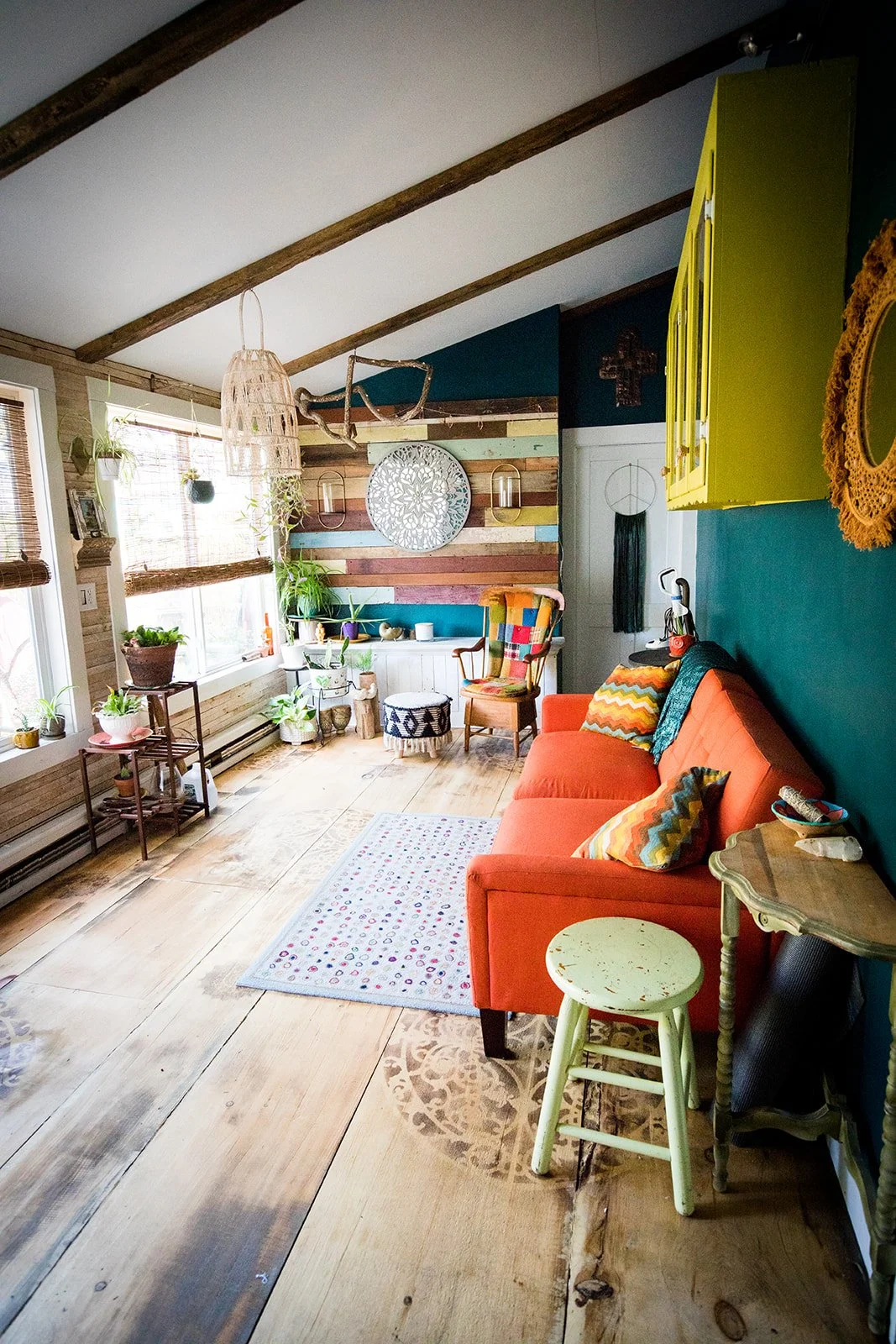 Interior of a rustic thrift shop with various furniture, shelves, and decor, including a sign that reads 'Come in, stay a while' and a green arch-shaped wall decoration.