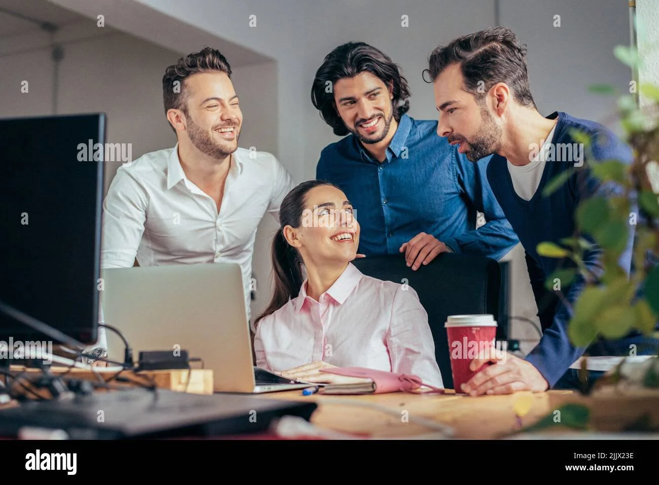 group-of-smiling-multiracial-coworkers-in-formal-clothes-browsing-netbook-while-working-together-on-business-project-in-modern-light-office-2JJX23E-1099962325.jpg