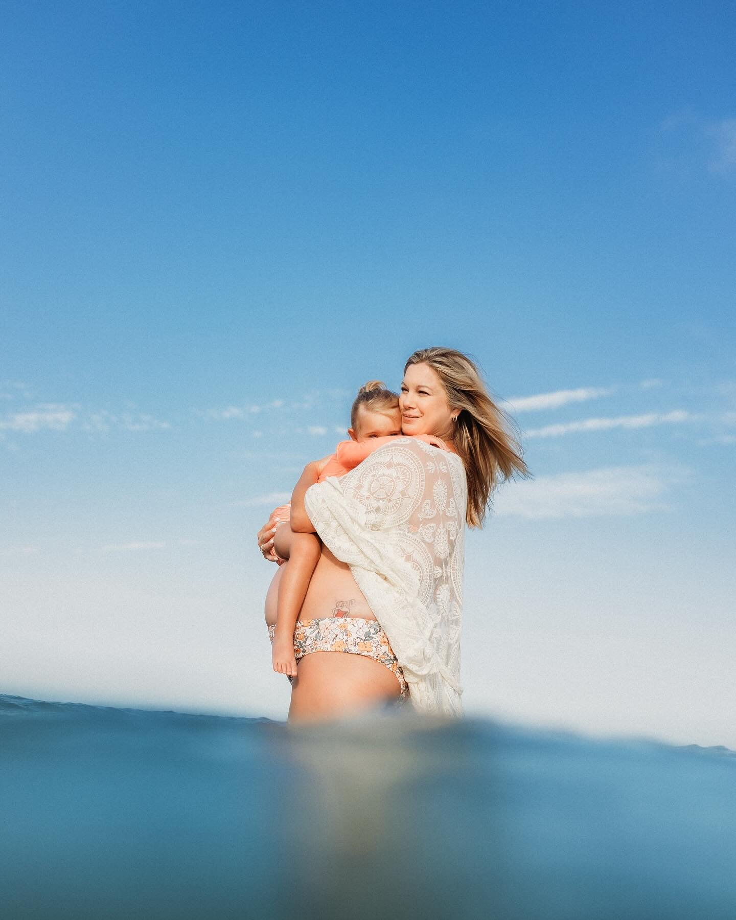 As mother and her daughter held one another amidst the gentle ease of the ocean&rsquo;s embrace. With each splash and giggle, they seemed to embody the ethereal grace of mermaids, their laughter mingling with the whispers of the sea. In this enchanti