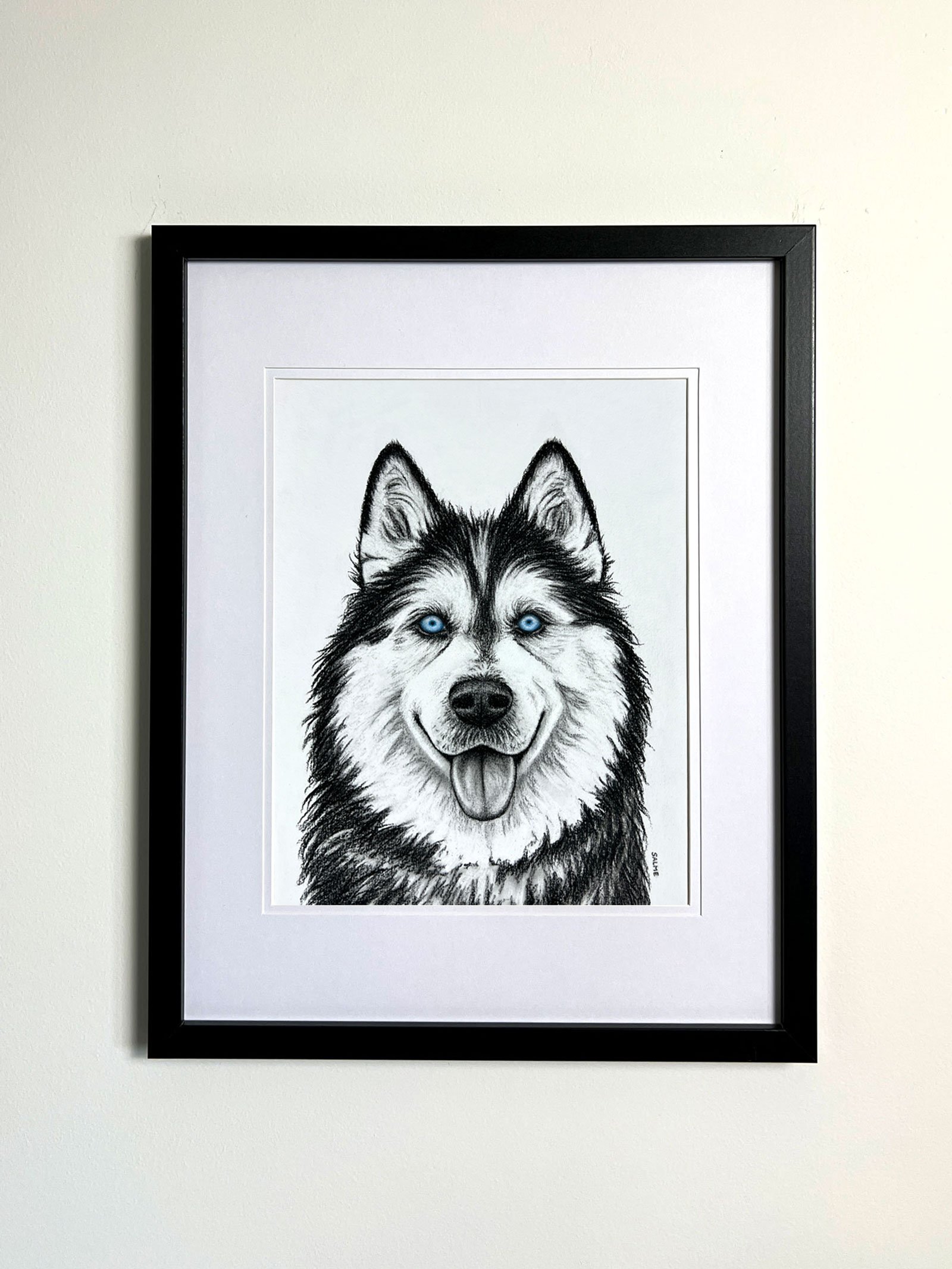 Original charcoal drawing of a husky framed on the wall.