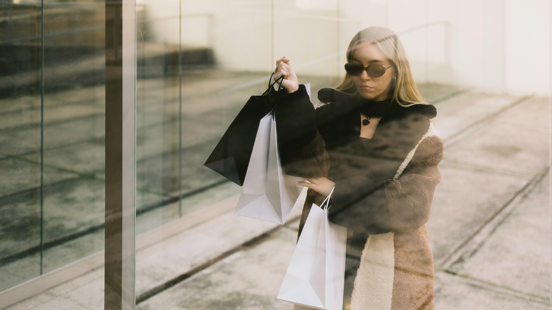 Woman holding shopping bags and looking at her reflection