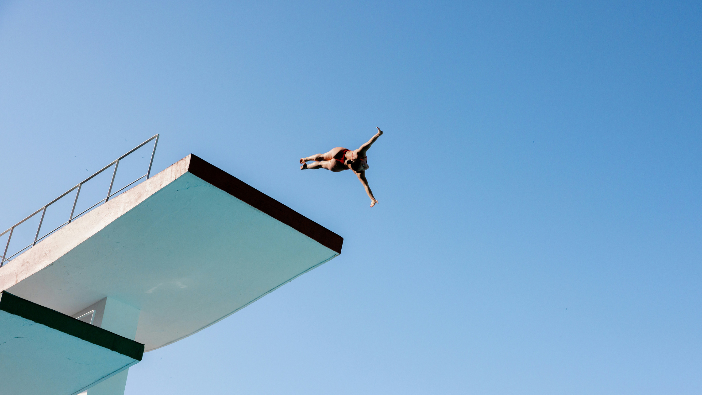 Woman diving head first off a diving platform