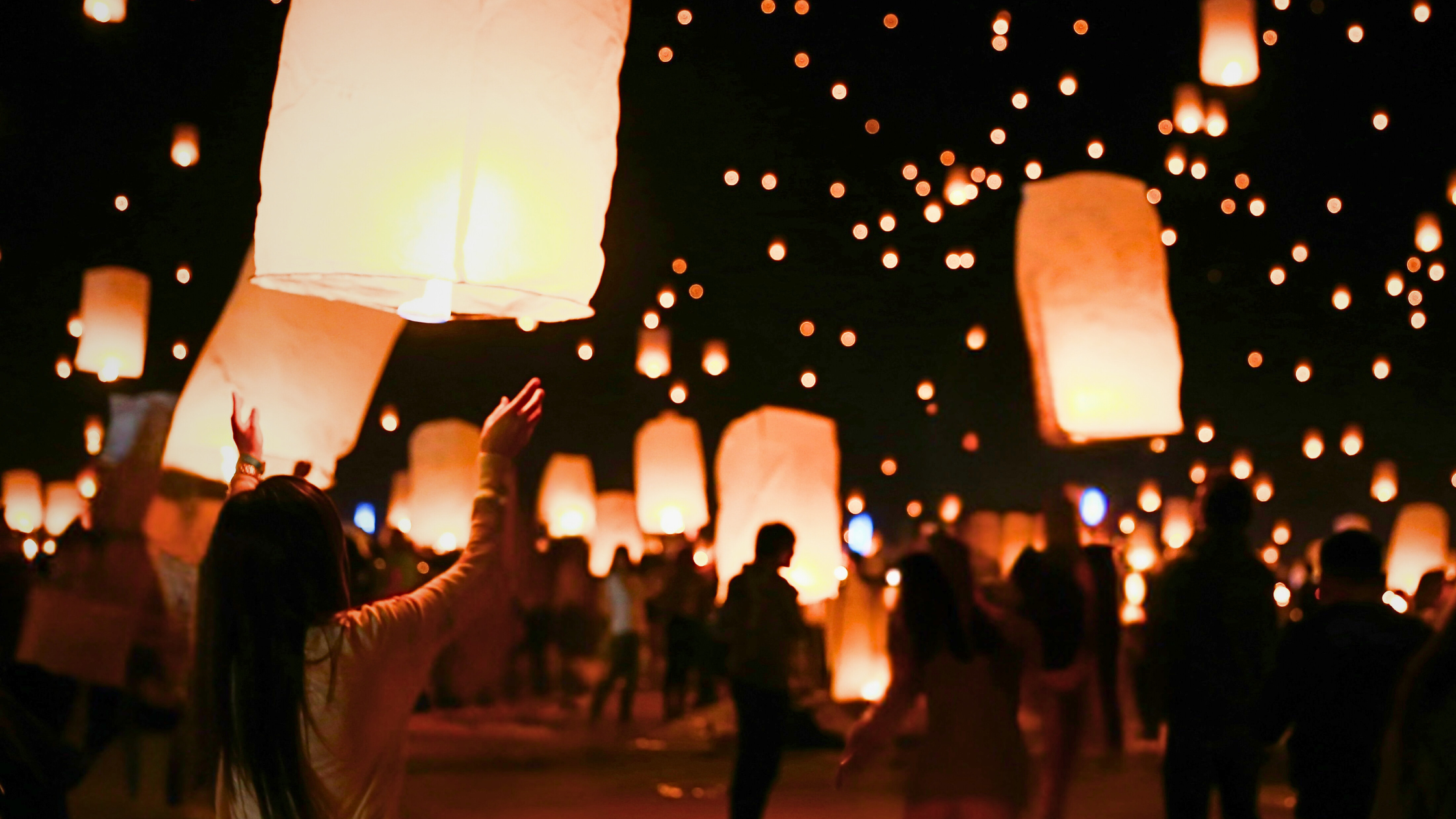 woman letting go of lantern at fesitval