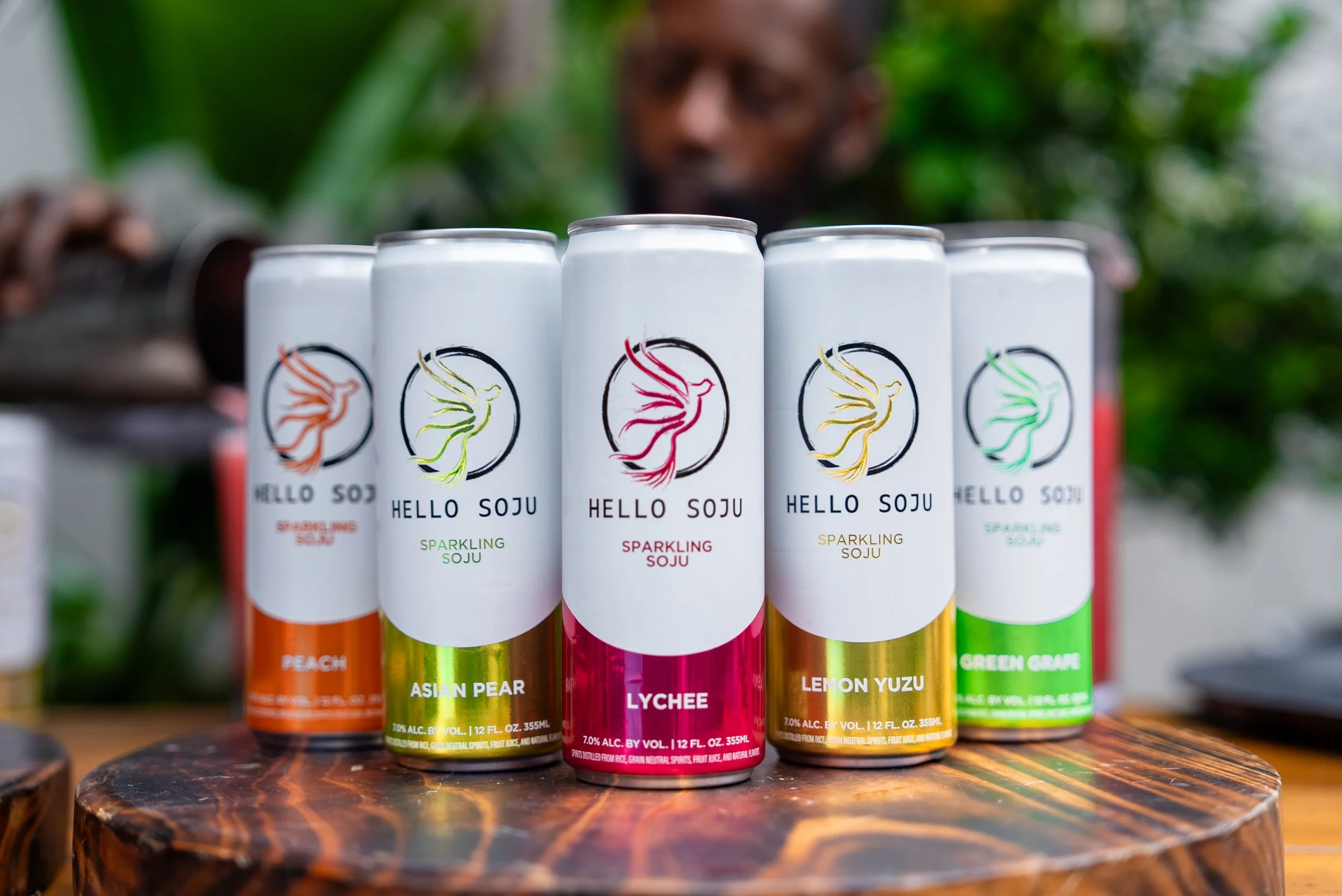 five cans of Hello Soju sparkling canned cocktails on a wood table