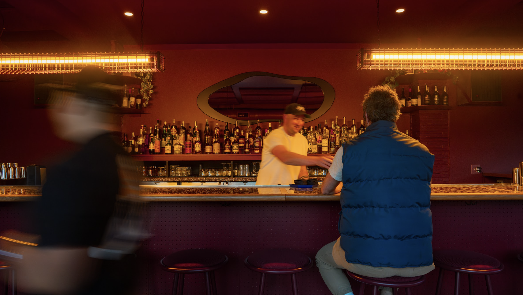 Bartender serving a drink to a customer at the bar inside Semiprecious in Denver