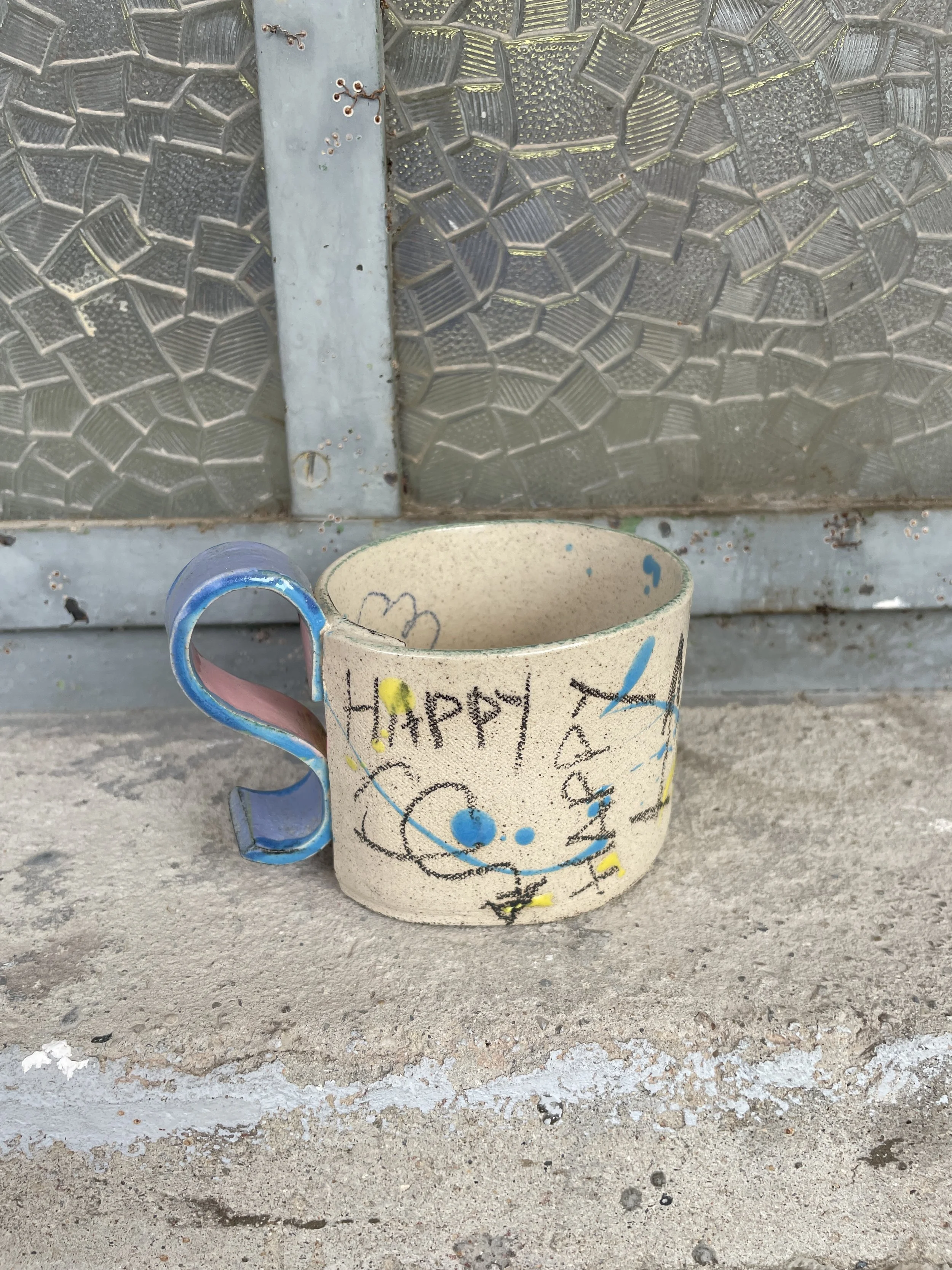Hand-painted funky porcelain mug showing blue splash detail and side handle.JPG