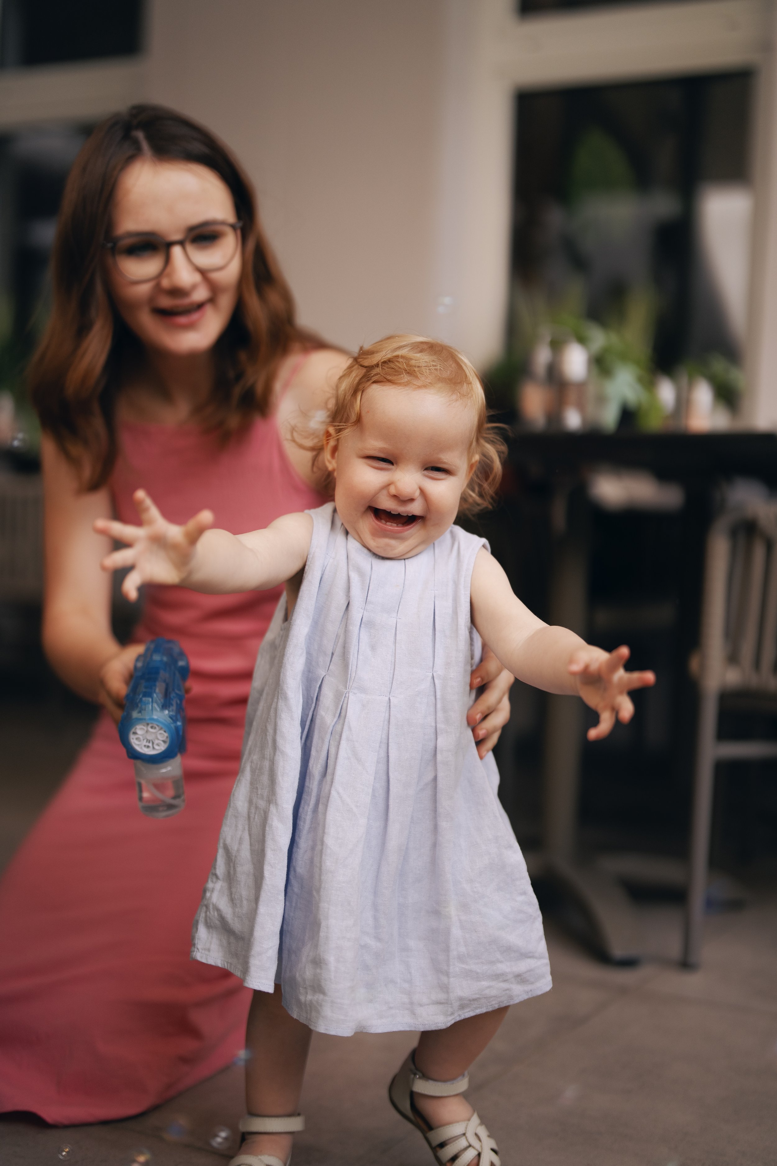 A little girl laughing and playing during the wedding reception.