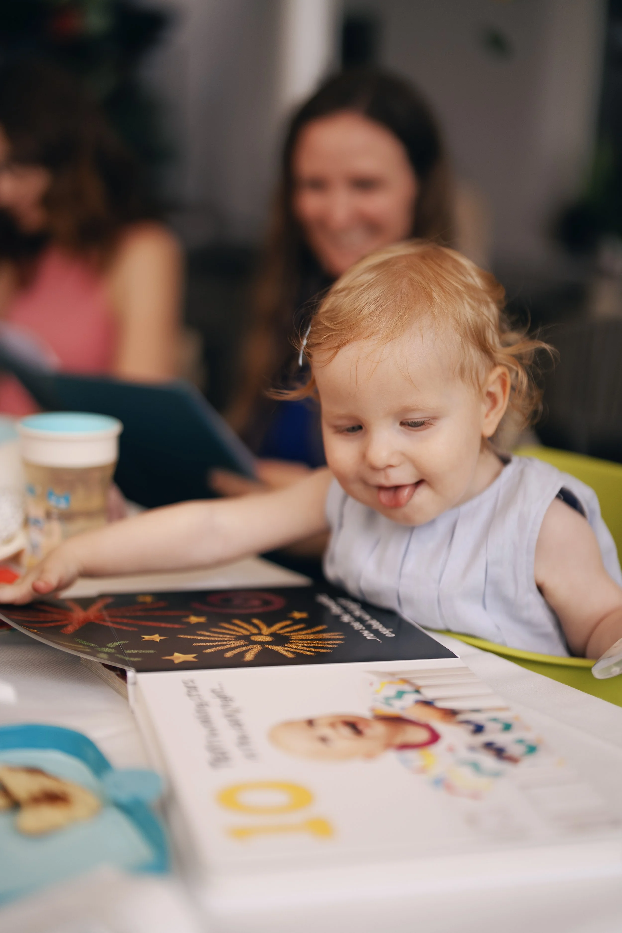A little girl flipping through a picture book during the wedding reception.