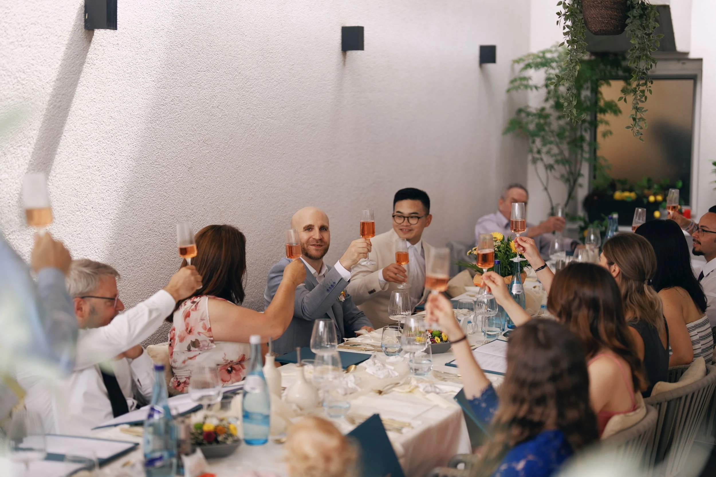 Two grooms making a toast during their wedding reception.