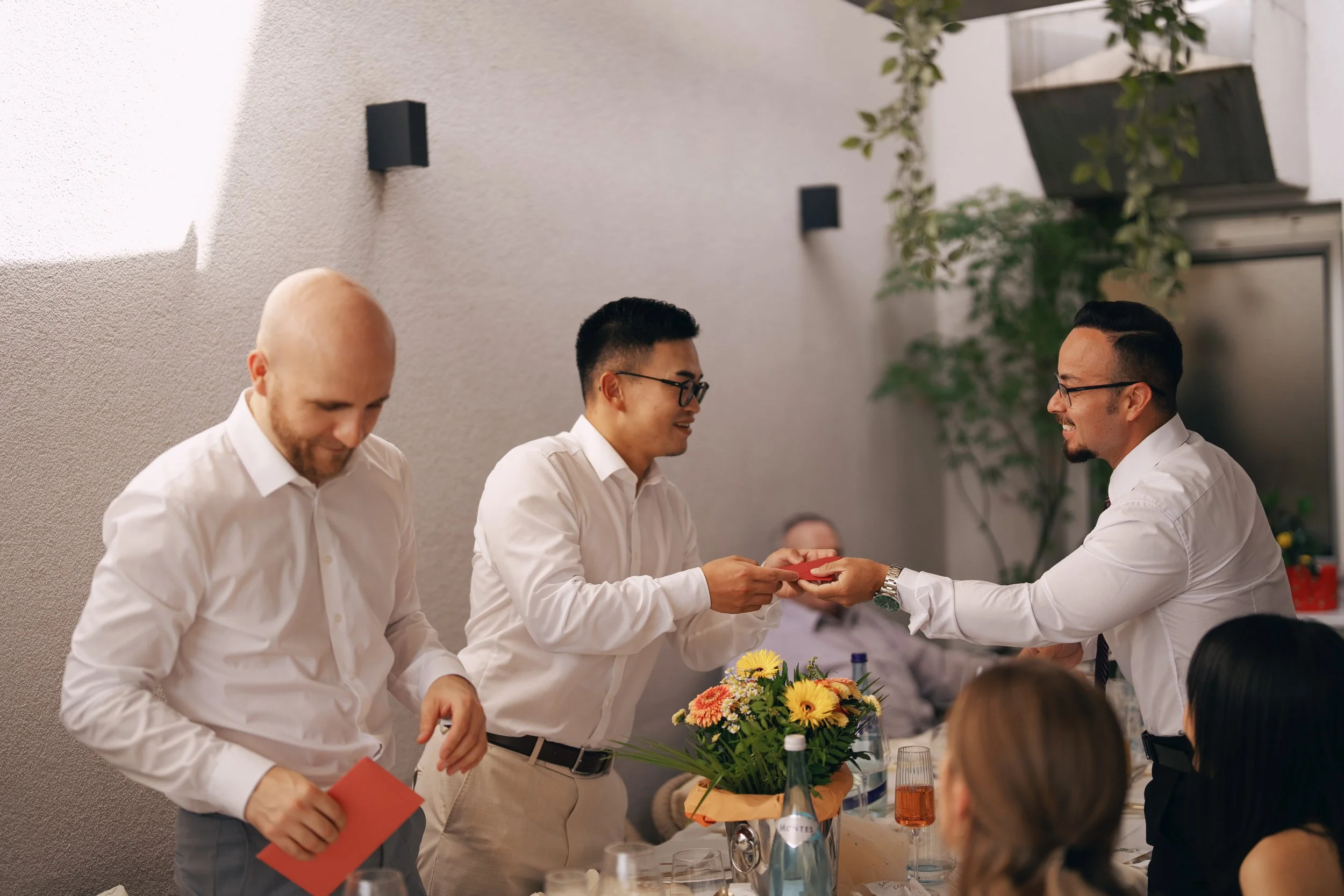 Two grooms toasting with family during the wedding reception.