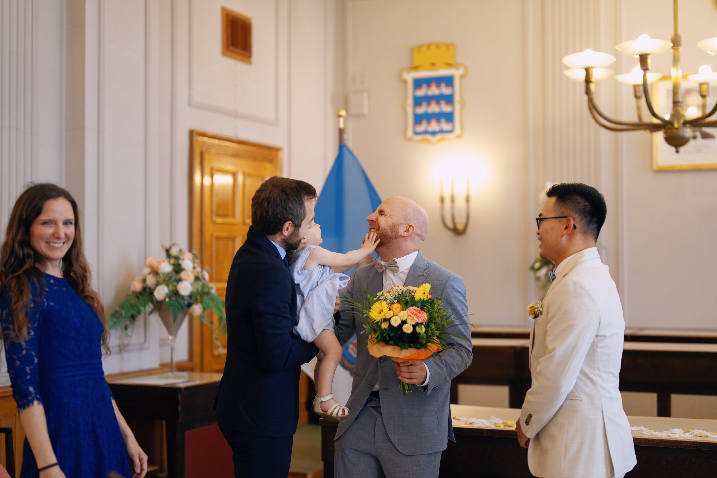 A little girl gently touching one groom's face after the ceremony.