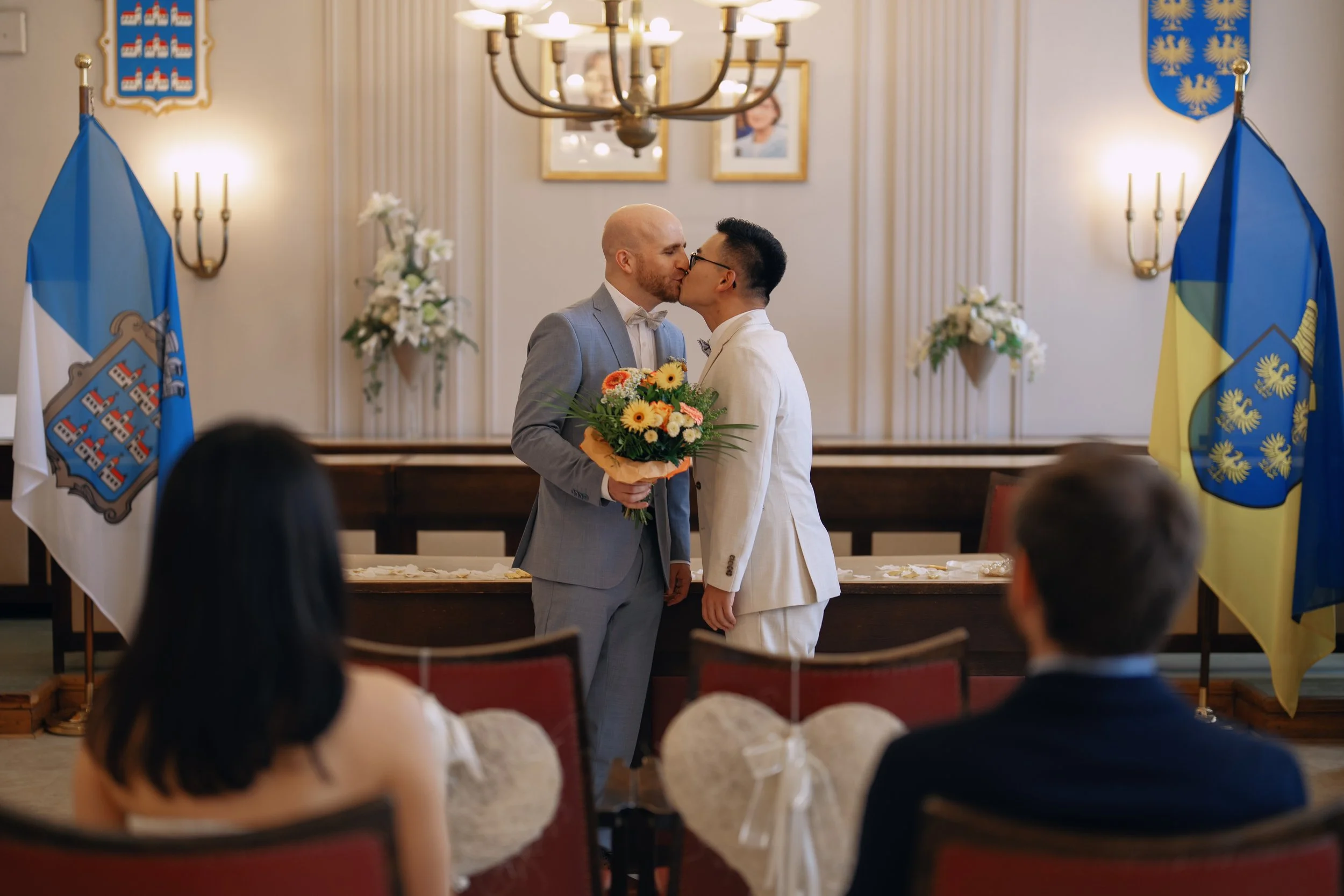 Two grooms holding their wedding bouquet after the ceremony.