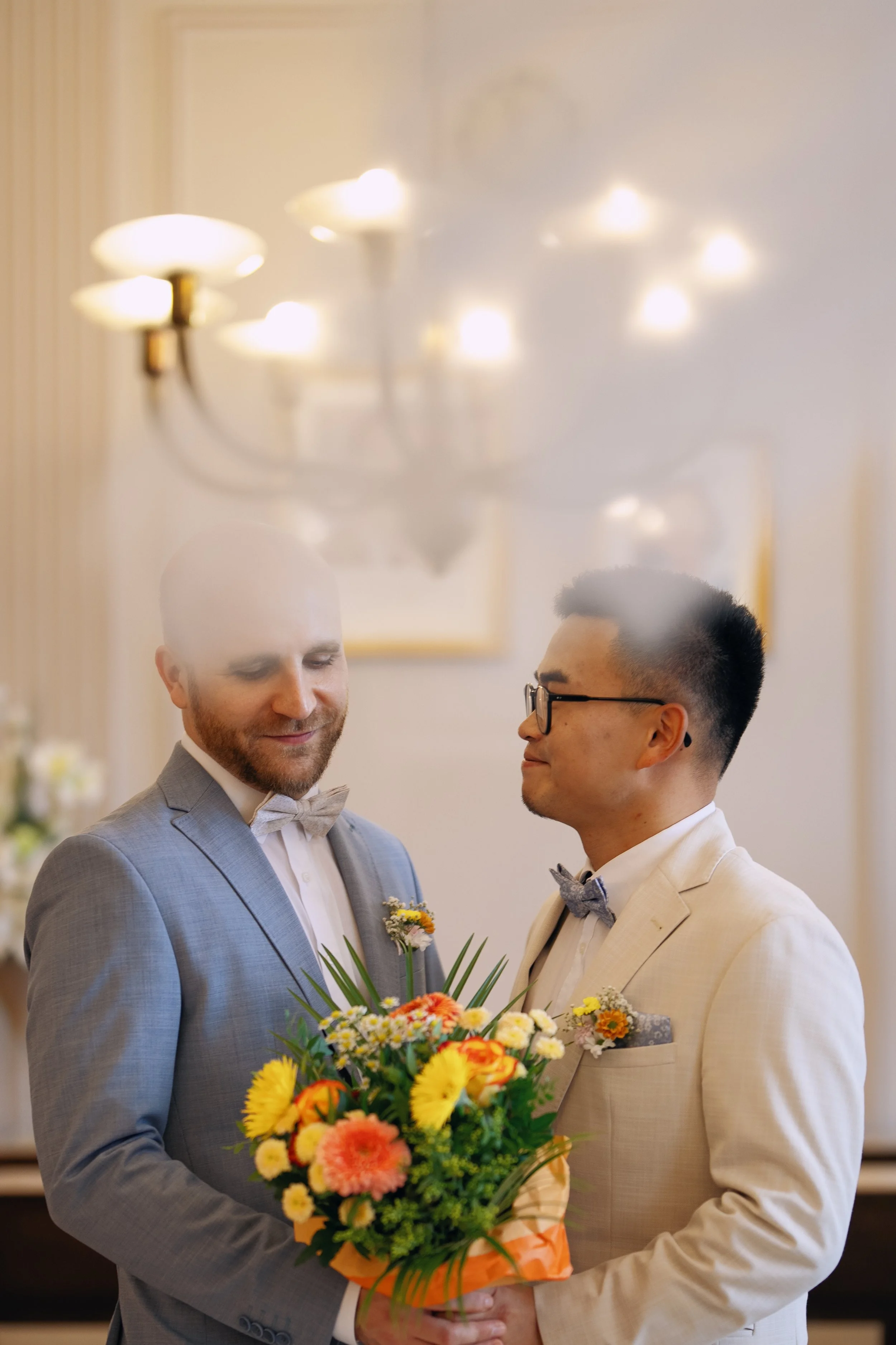 Two grooms smiling at each other after their civil wedding ceremony.