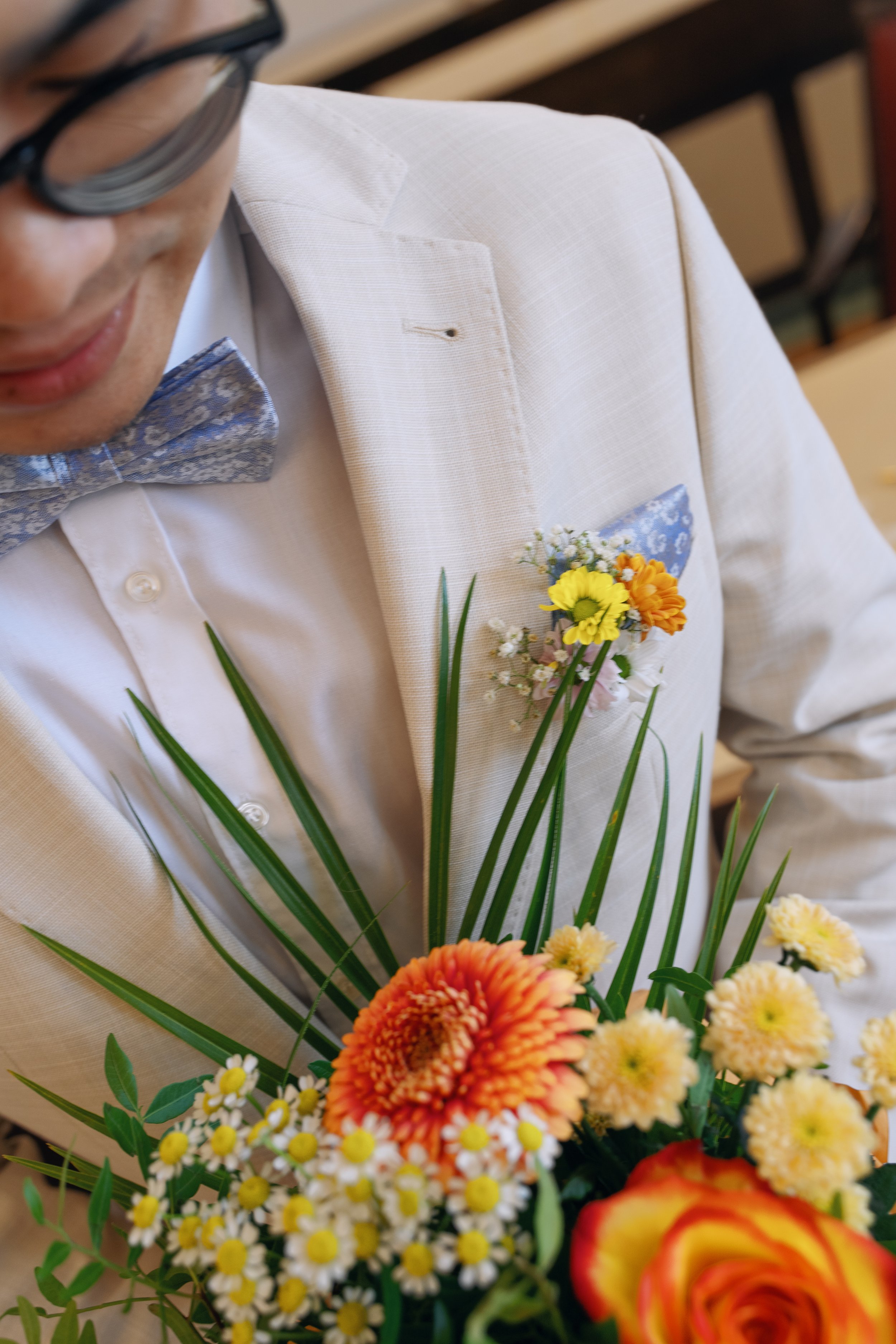 Close-up of a groom's boutonniere with colorful wedding flowers.