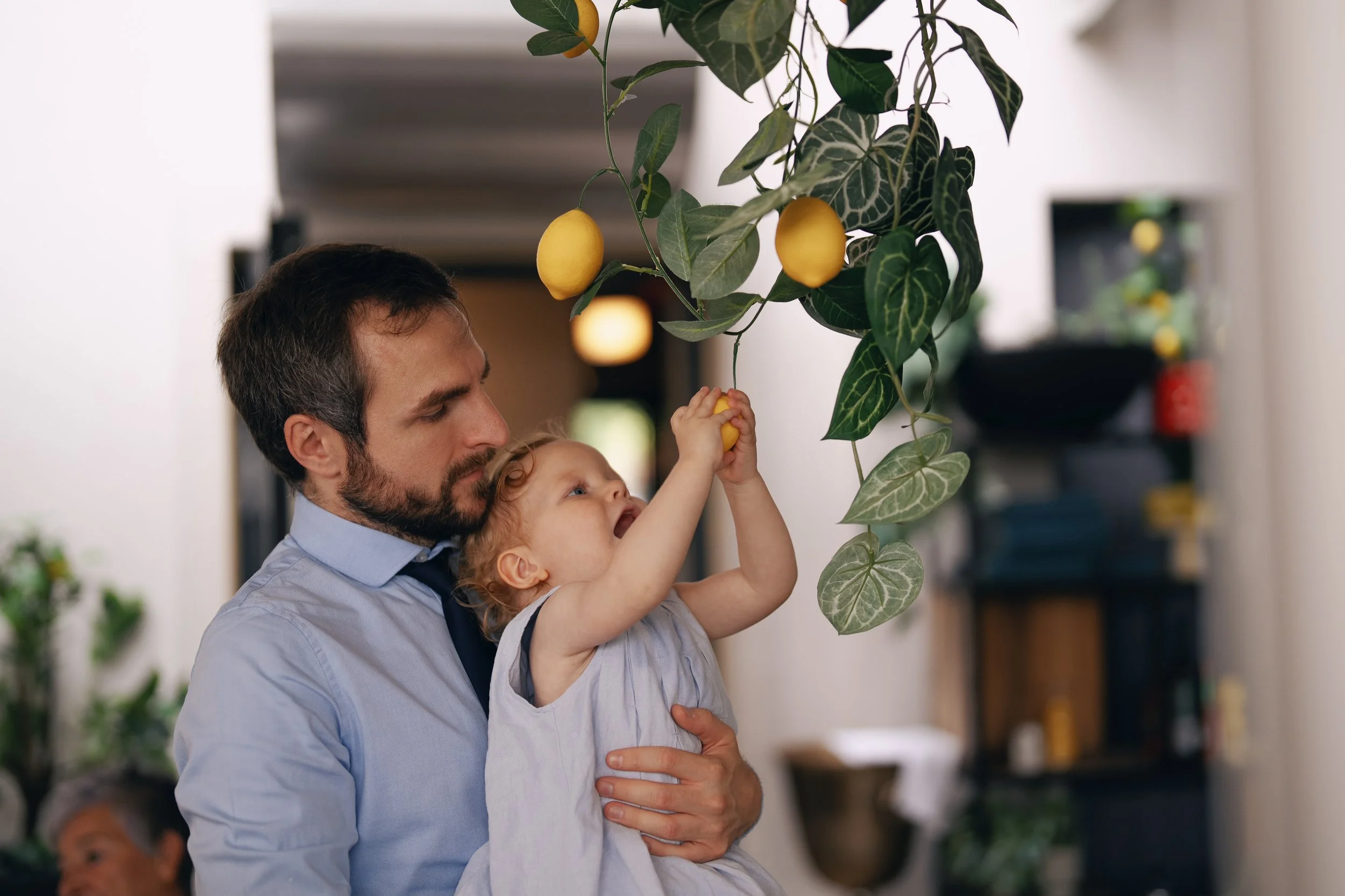 A father holding his daughter during the wedding reception.