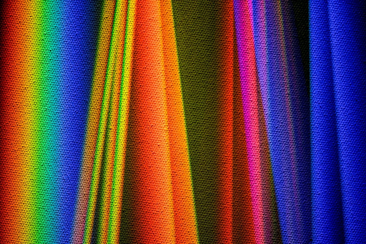 Close-up of vibrant multicolored woven fabric with vertical rainbow stripes