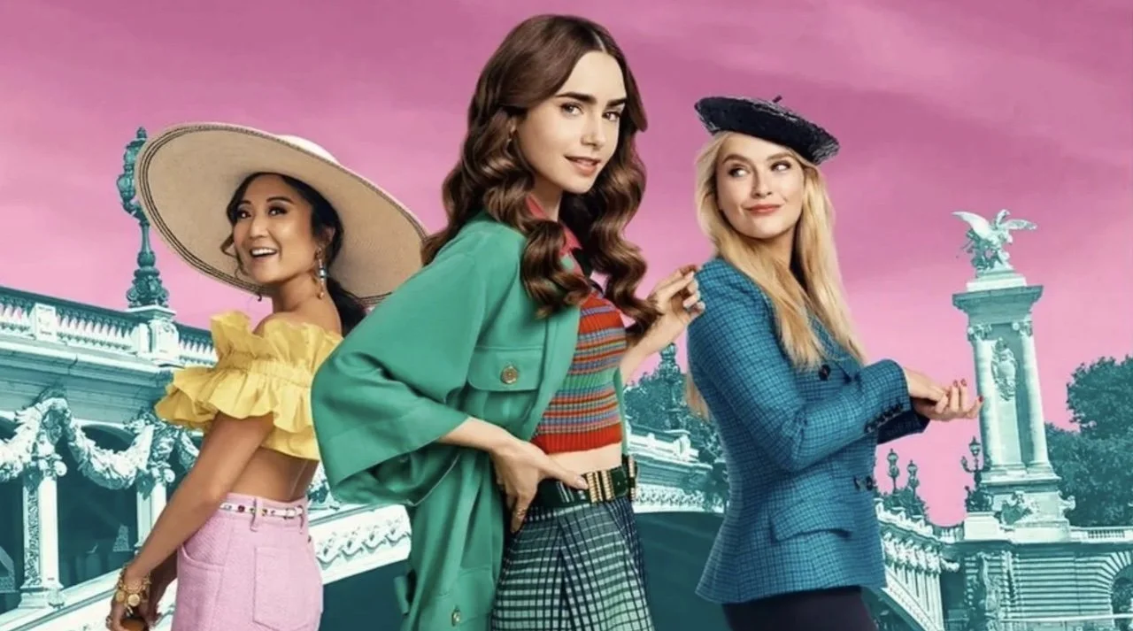 Drei Frauen in modischer Kleidung und Hüten vor einer künstlerisch bearbeiteten Kulisse mit einer Statue und einem rosa Himmel, vermutlich im Park oder auf einer Brücke.