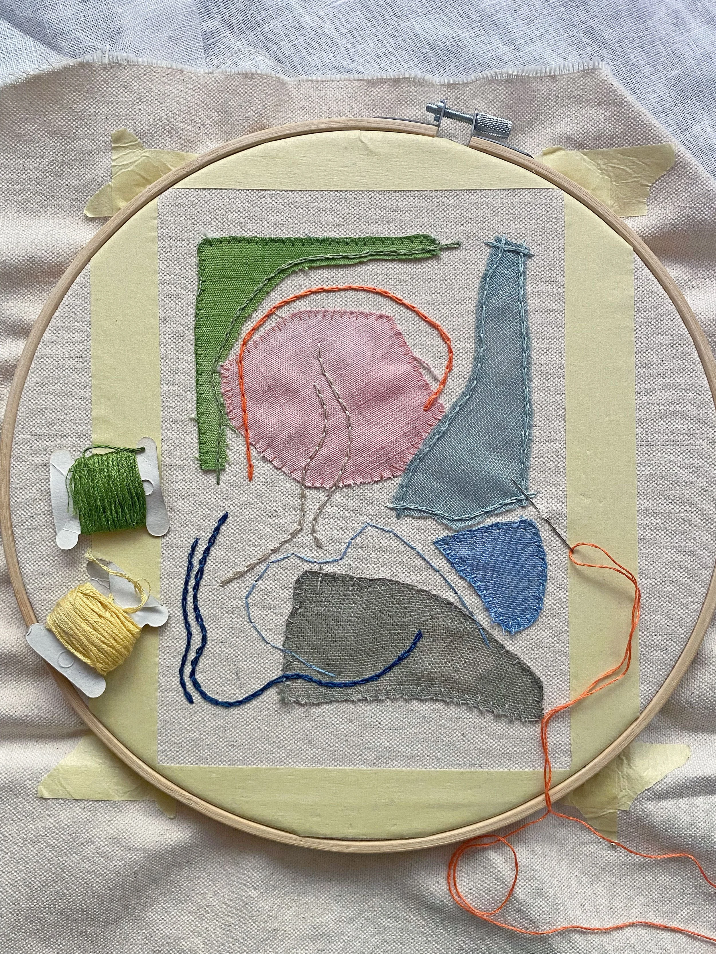 Embroidery hoop with abstract fabric and thread art