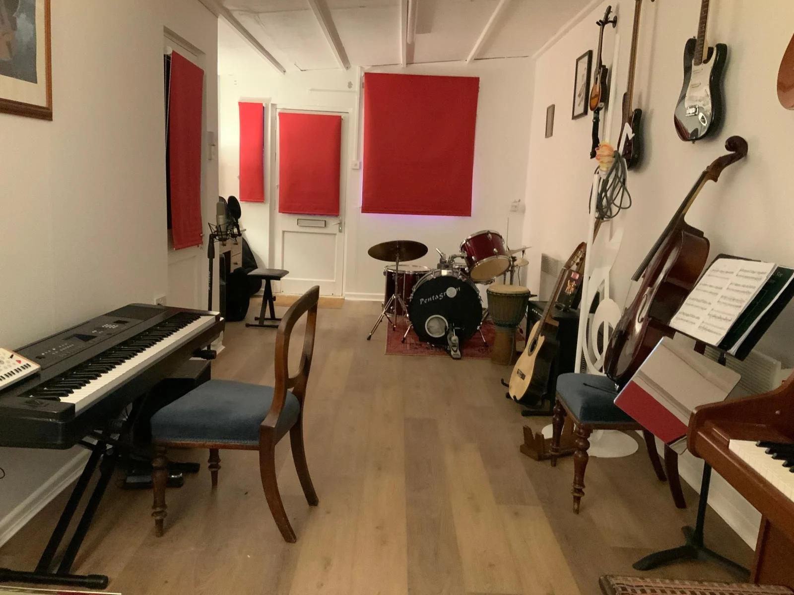 Music room with keyboard, drum set, guitars, and music stands