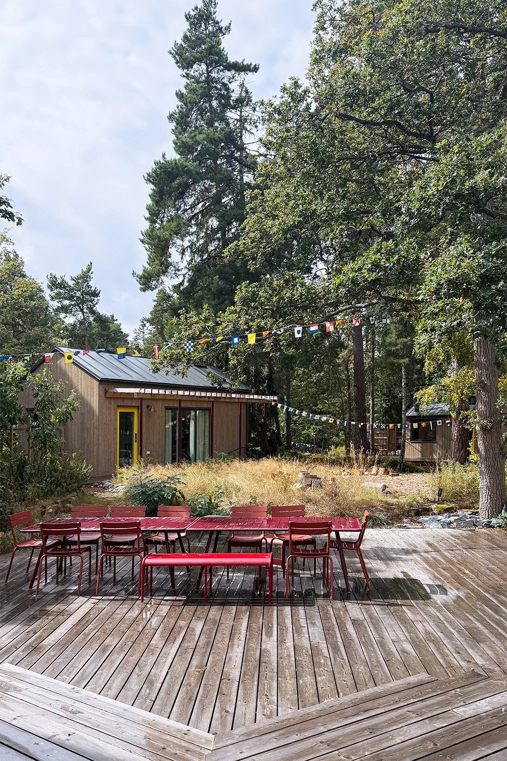 Winroth arkitekter, arkitektritad, attefallshus, atttefallsstuga, övernattning, sommarhus, arkitektur, semesterbostad, stockholms skärgård, tratten, röda utomhusmöbler, flaggspel, campsite