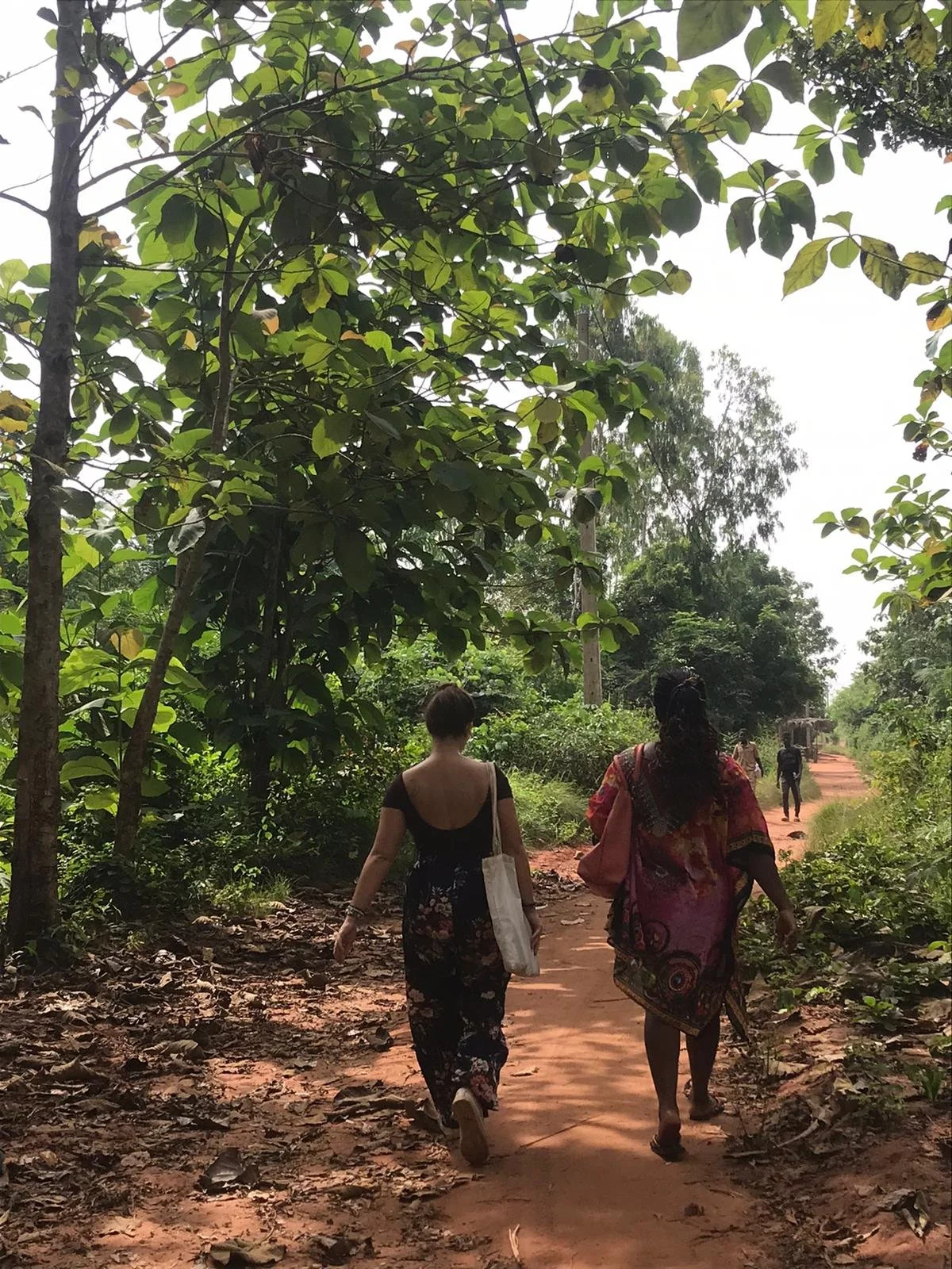Laura marchant avec une autre femme sur un chemin menant à la maison des volontaires