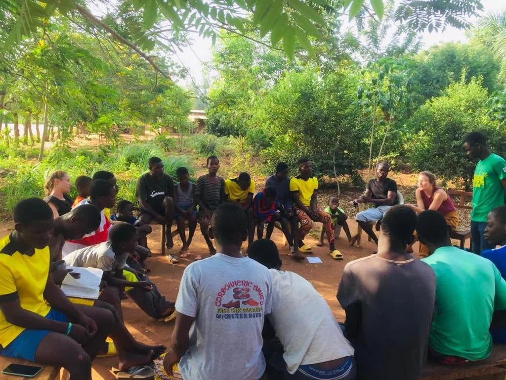 personnes en cercles composés de jeunes togolais et de volontaires