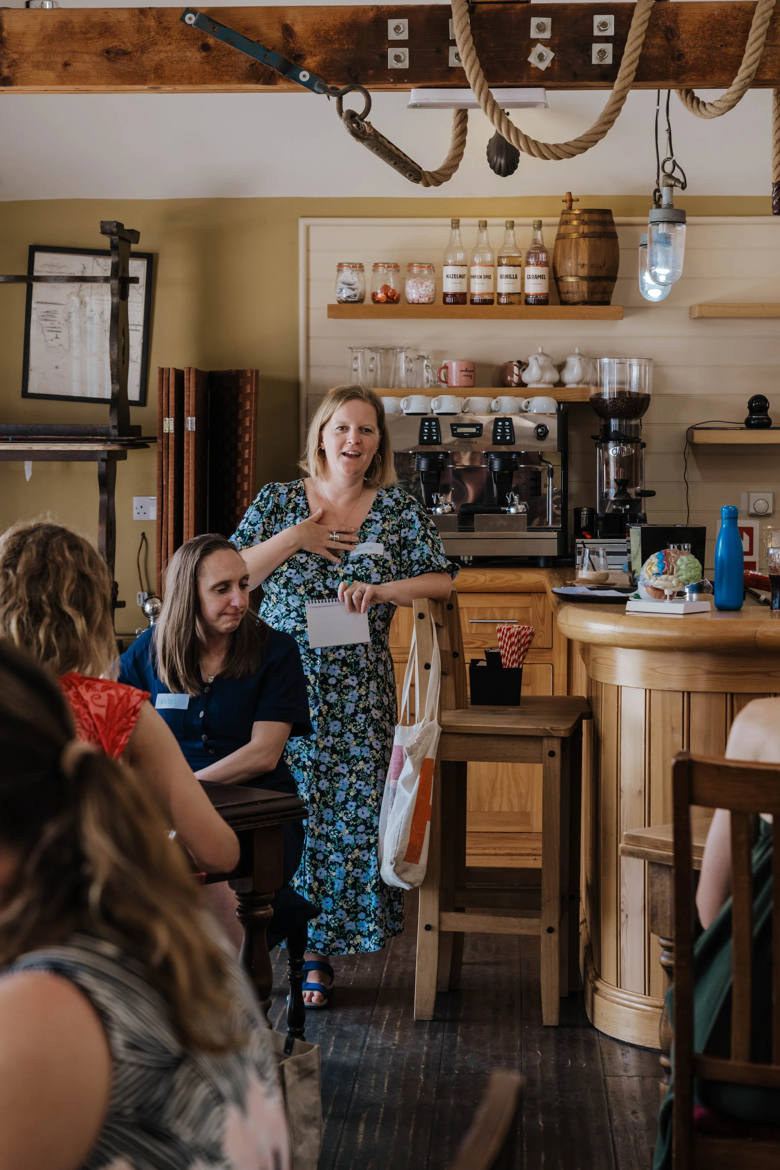 Gemma Gooch talking with attendees at a coffee shop networking event