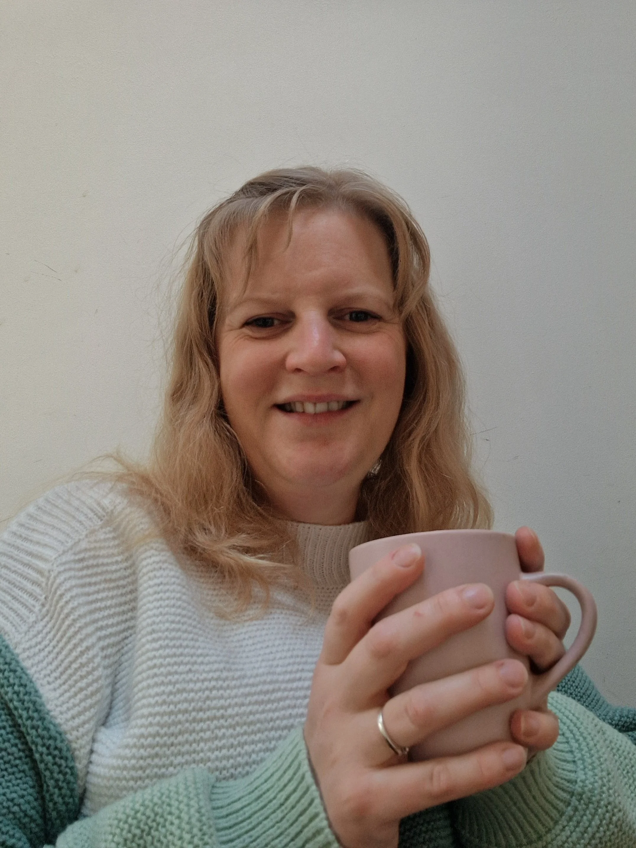 Image of Gemma, a blonde woman, holding a pink mug