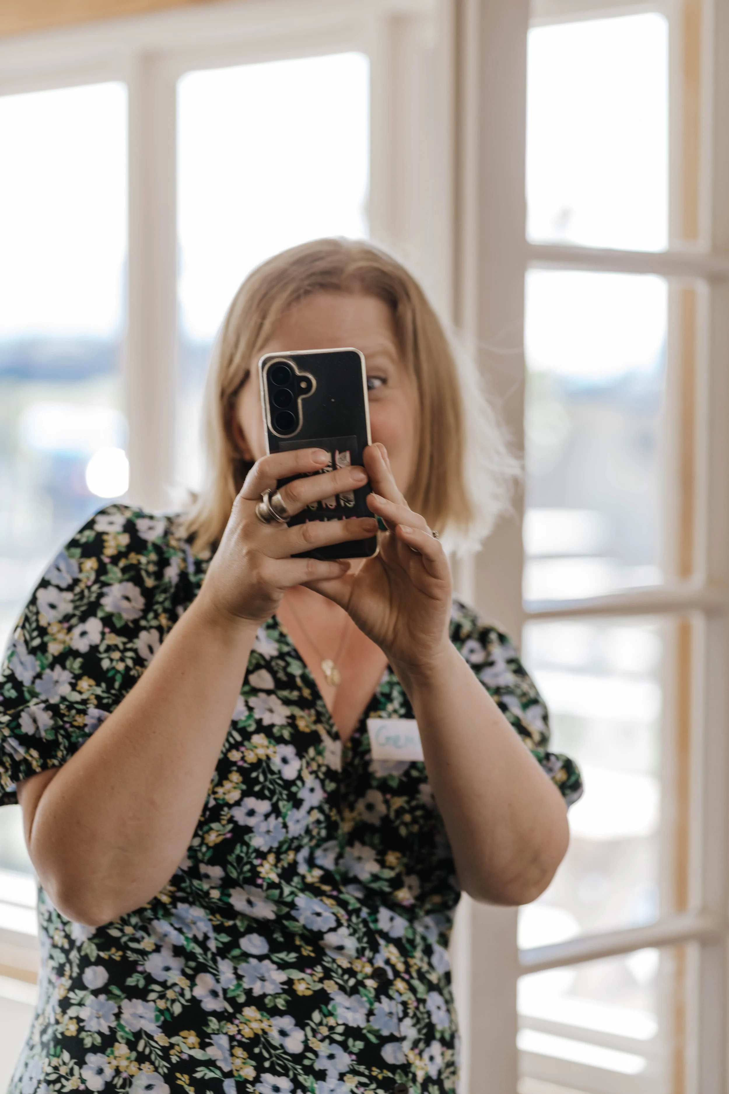 Woman taking a photo on a camera at a business networking event
