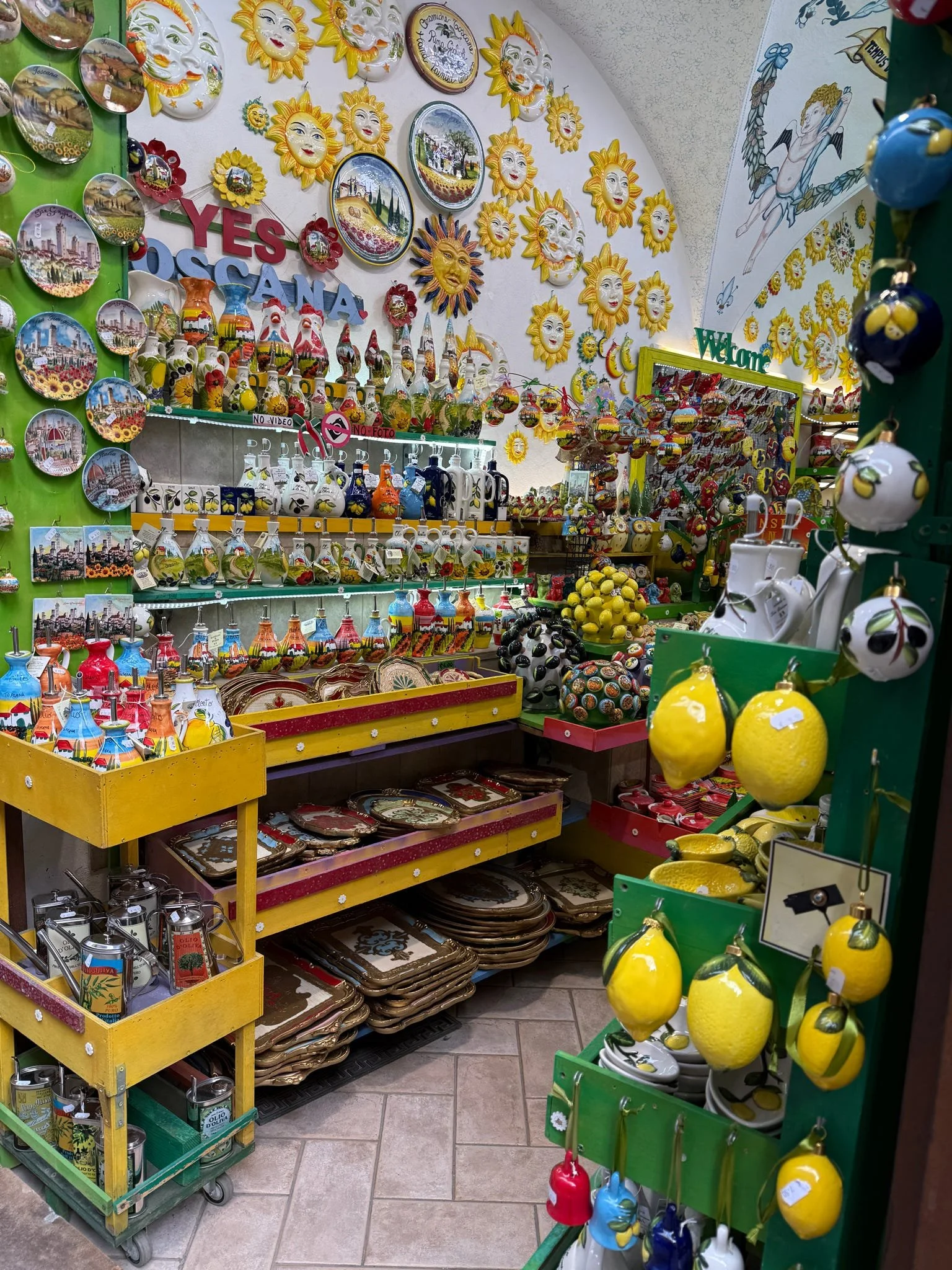 Colorful souvenir shop filled with ceramic sun, lemon, and cityscape decorations, plates, and other decorative items.