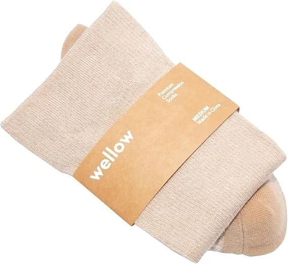 Beige compression socks with a brown paper band labeled 'wellow' and size 'Medium' around the middle.
